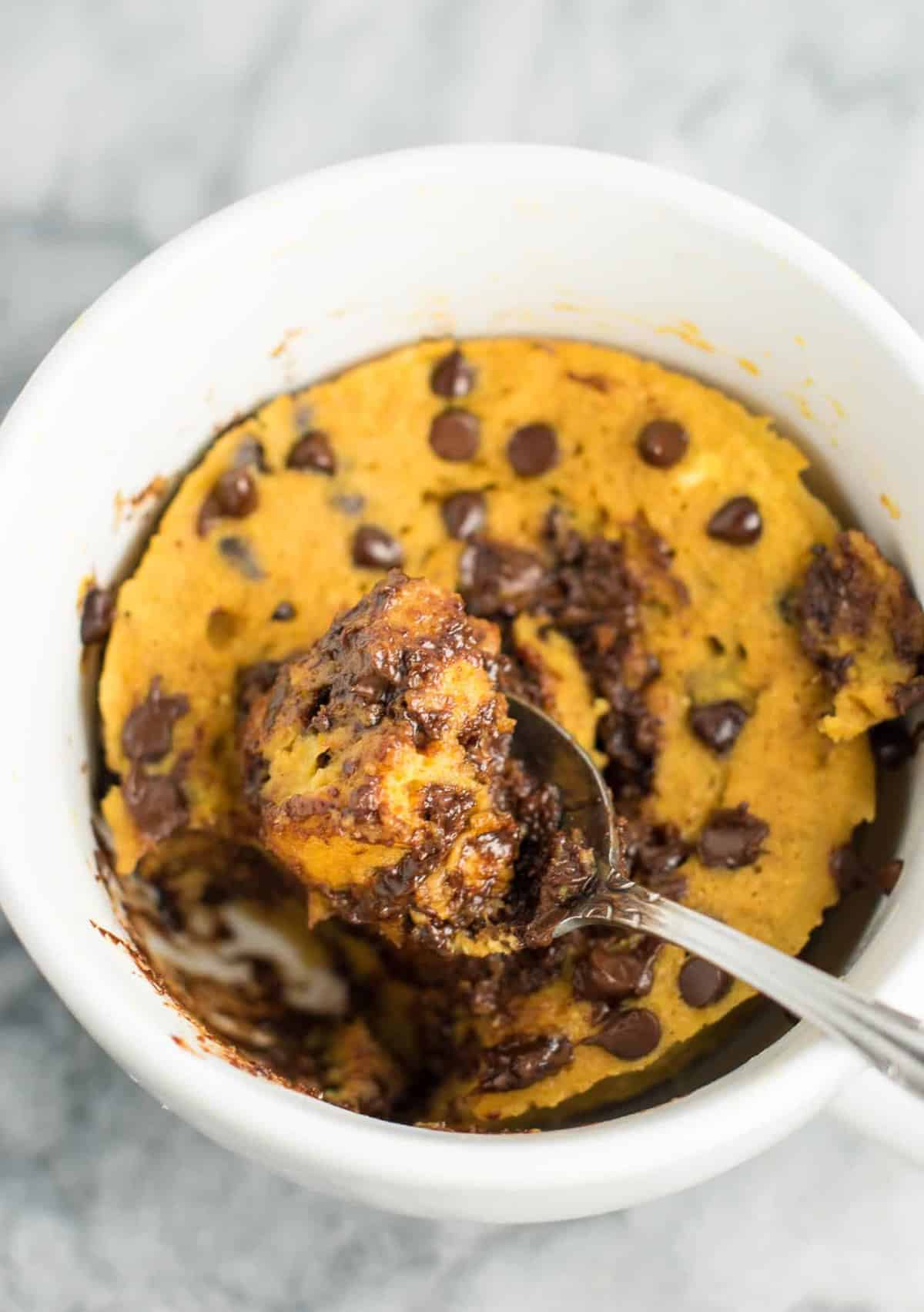 taking a spoonful of pumpkin chocolate chip mug cake