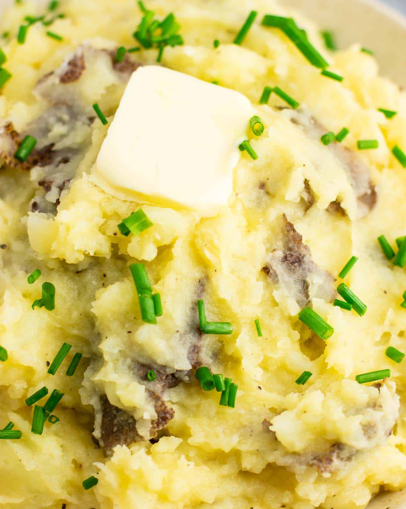 mashed potatoes up close topped with a pat of vegan butter