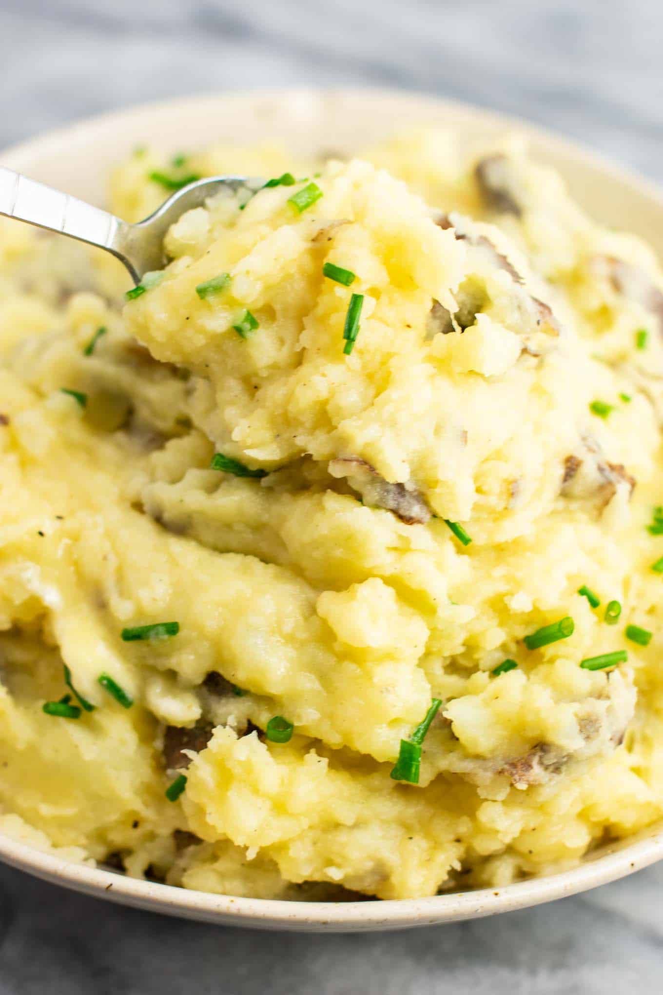 a spoon taking a scoop of mashed potatoes