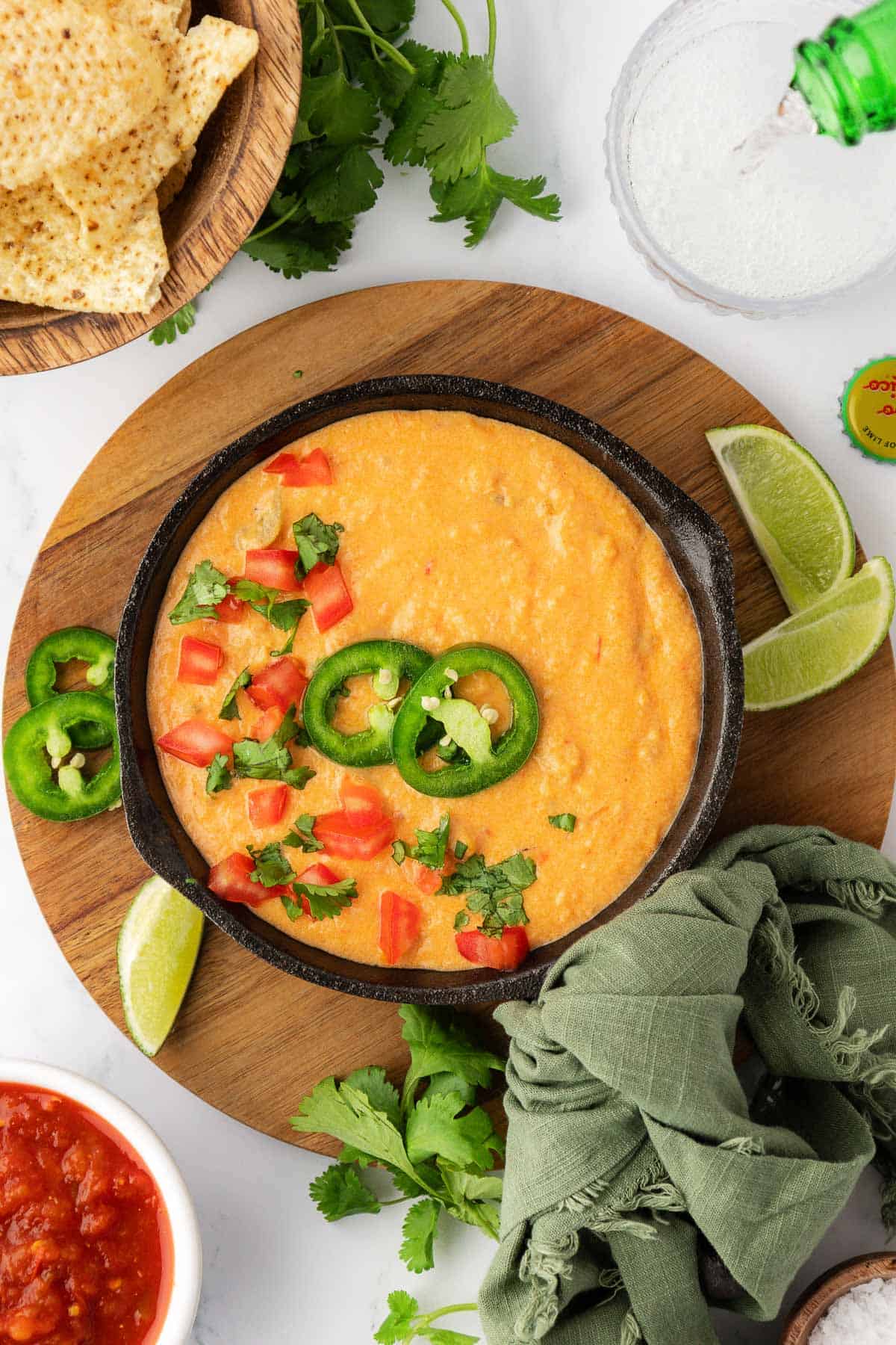 queso dip in a serving dish topped with pico and jalapenos