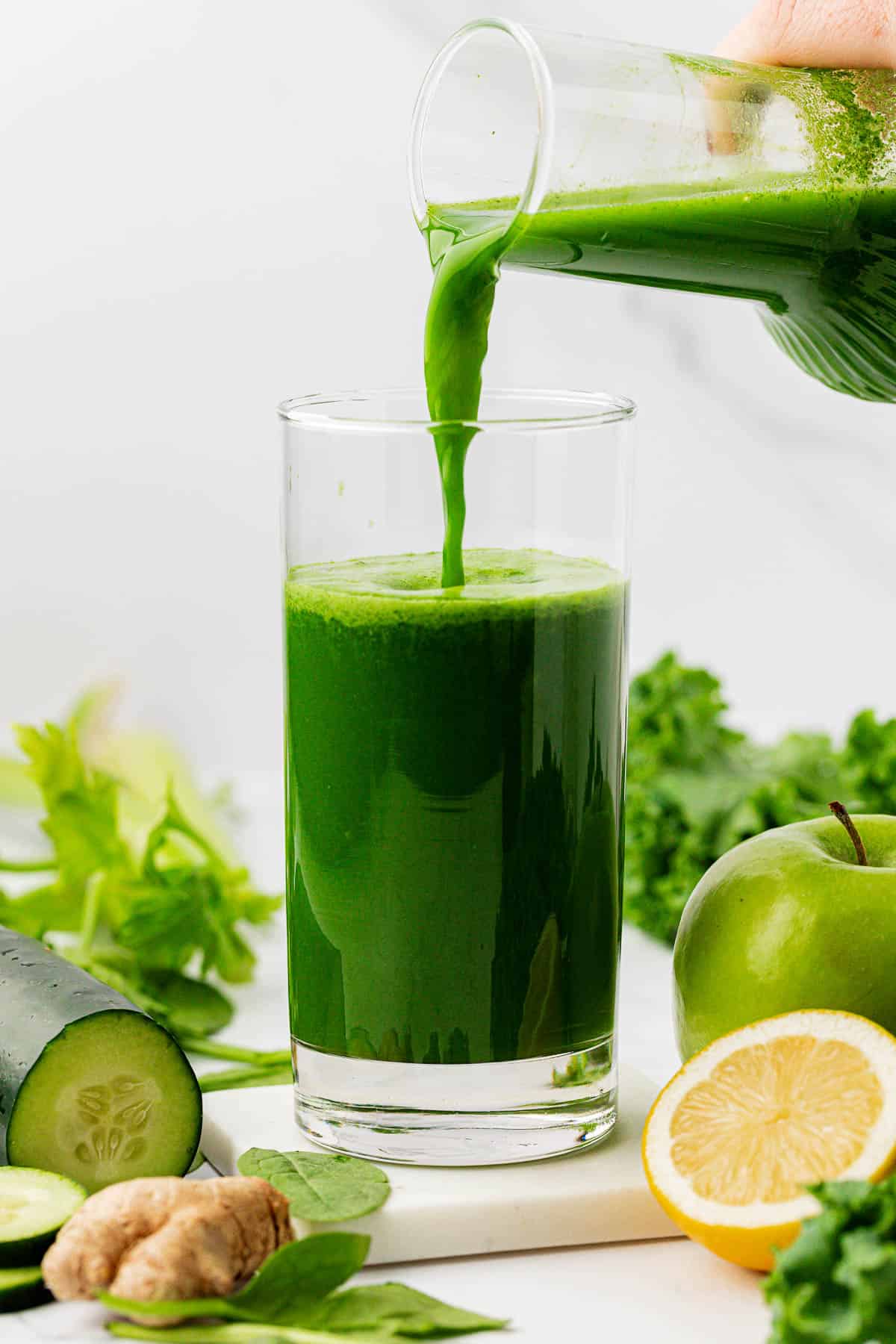 pouring green juice into a glass