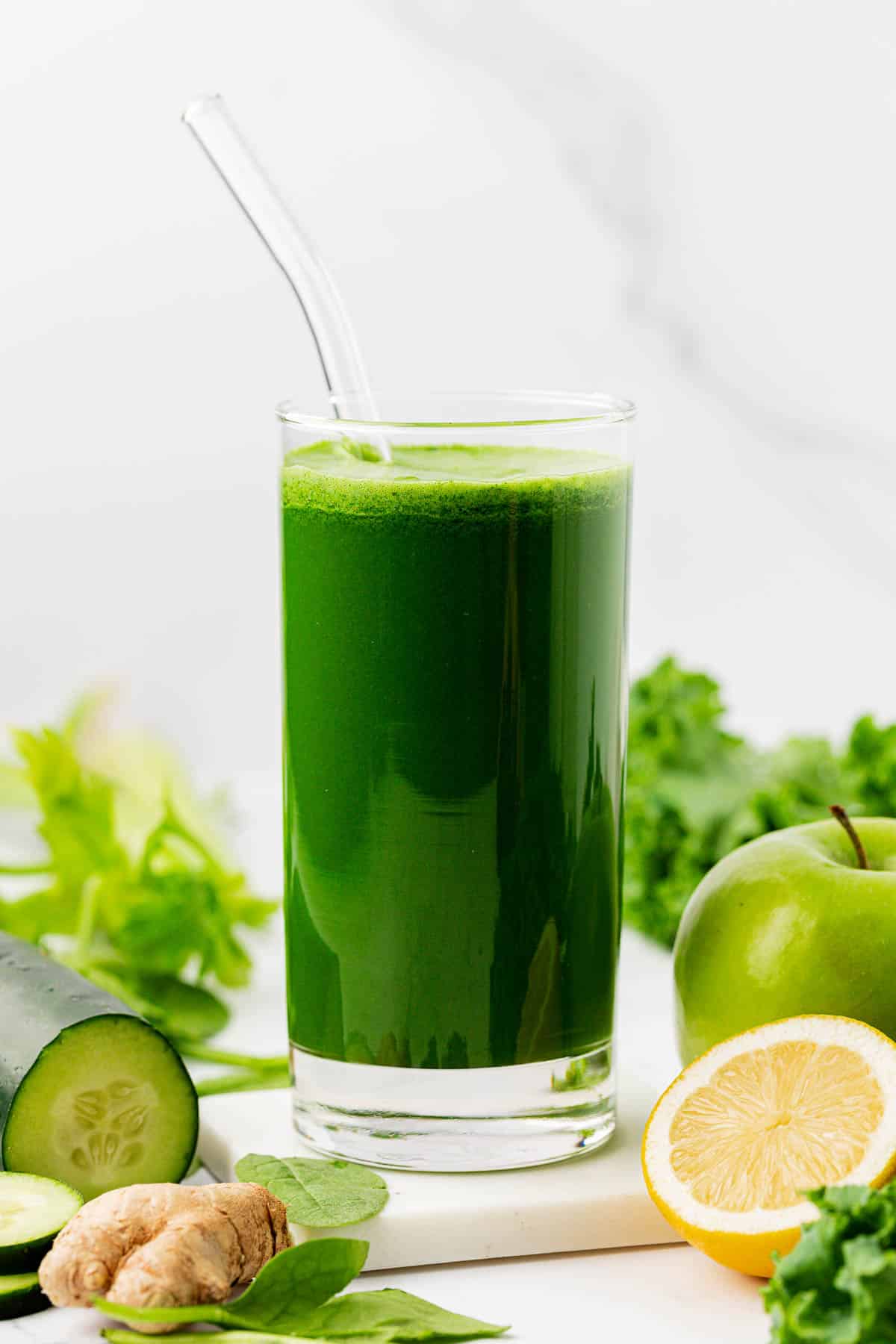 green juice in a glass with a straw
