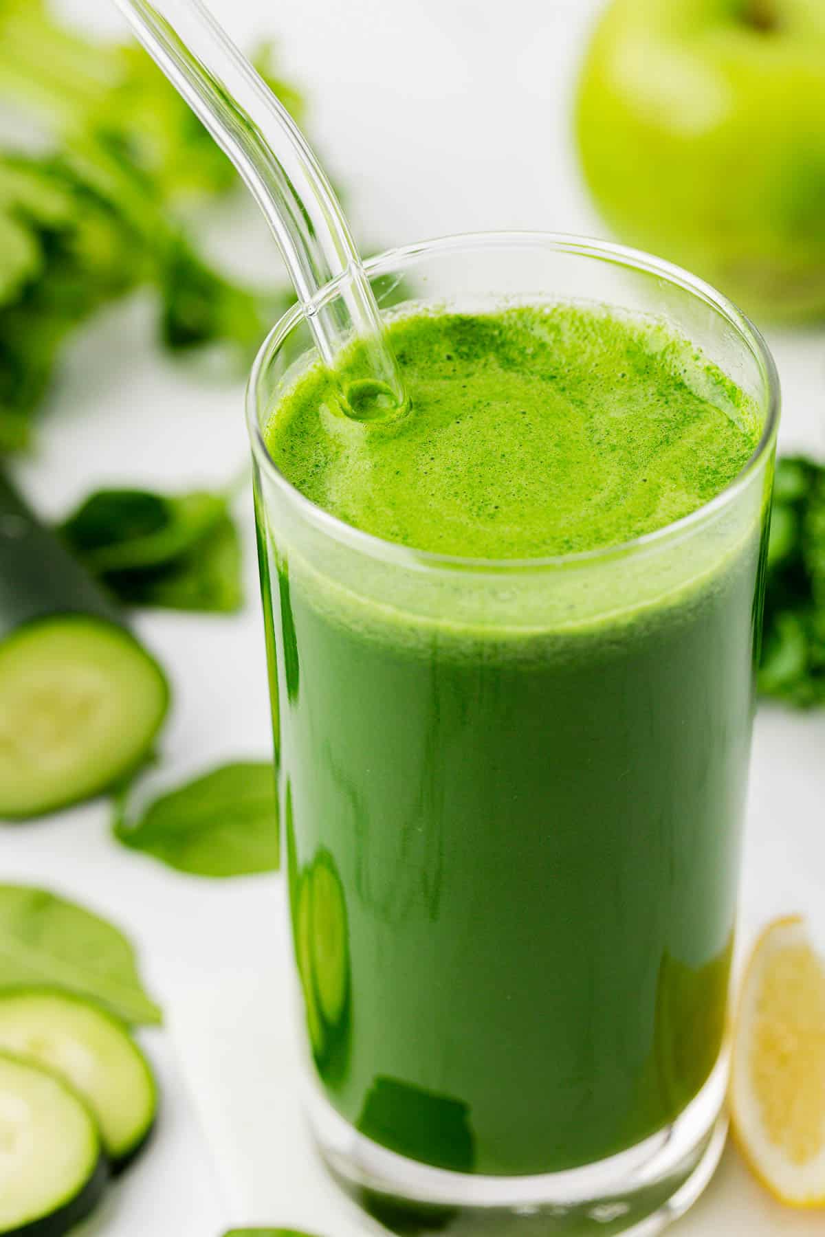 green juice in a glass with a straw