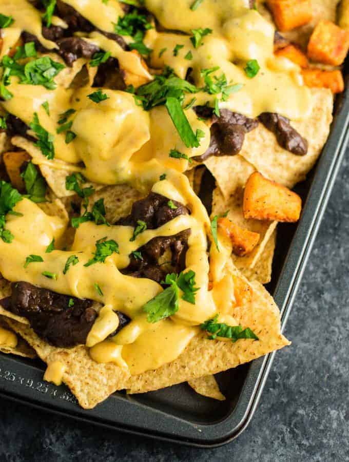 30 minute sweet potato refried bean nachos with homemade nacho cheese sauce. This is our go to Mexican meal! #30minute #vegetarian #sweetpotatonachos #sweetpotato #glutenfree #nachocheesesauce