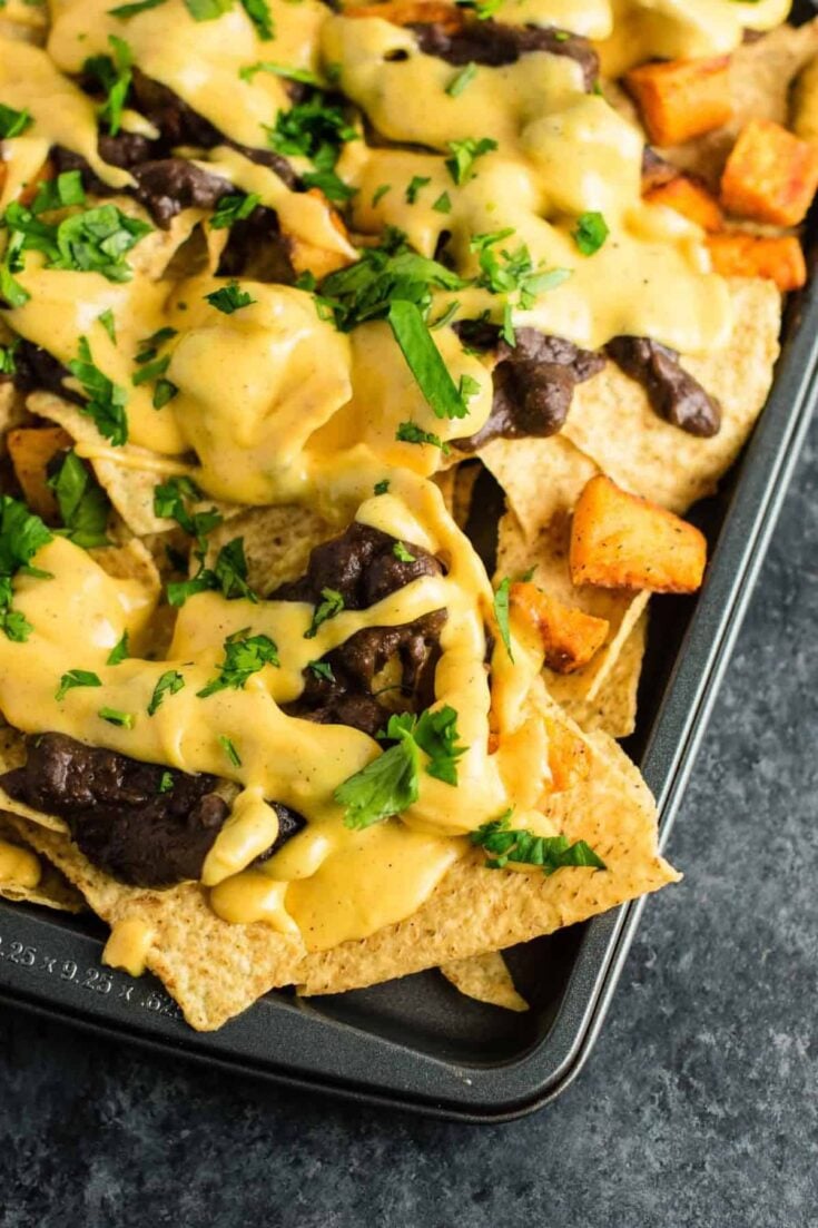 30 minute sweet potato refried bean nachos with homemade nacho cheese sauce. This is our go to Mexican meal! #30minute #vegetarian #sweetpotatonachos #sweetpotato #glutenfree #nachocheesesauce