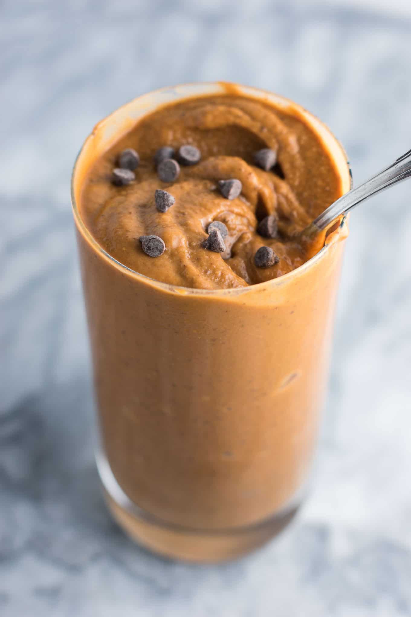 double chocolate milkshake sprinkled with mini chocolate chips in a glass with a spoon