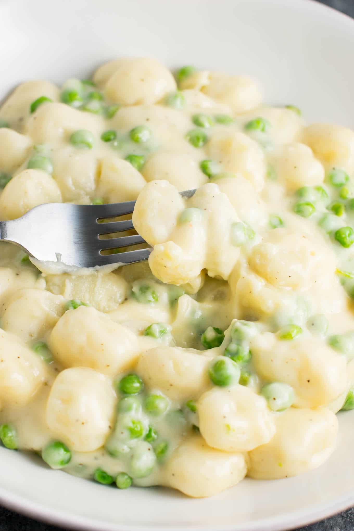 Ultra creamy gnocchi macaroni and cheese recipe with peas. A cheesy gnocchi comfort food recipe made in less than 15 minutes. 