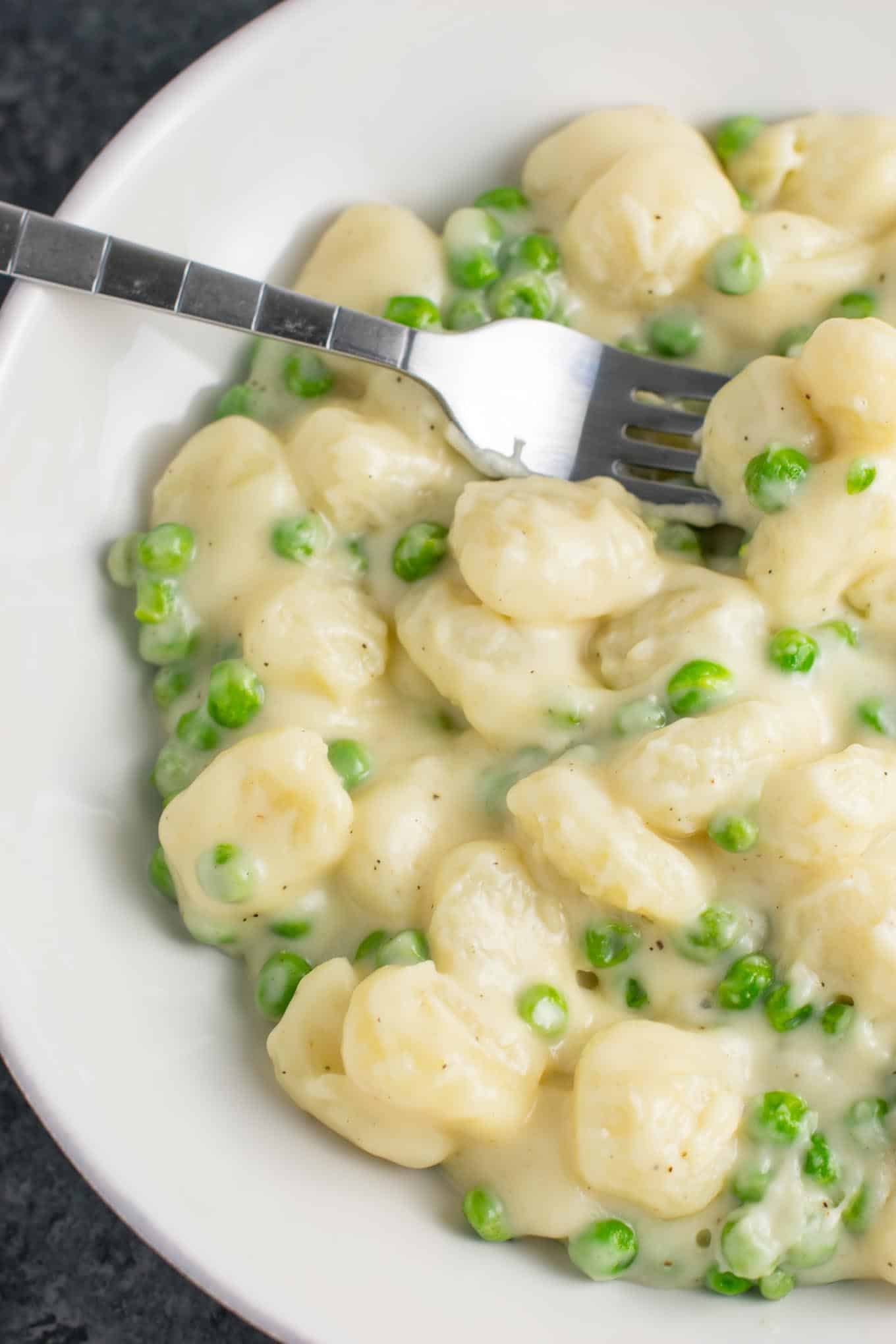 Ultra creamy gnocchi macaroni and cheese recipe with peas. A cheesy gnocchi comfort food recipe made in less than 15 minutes. 