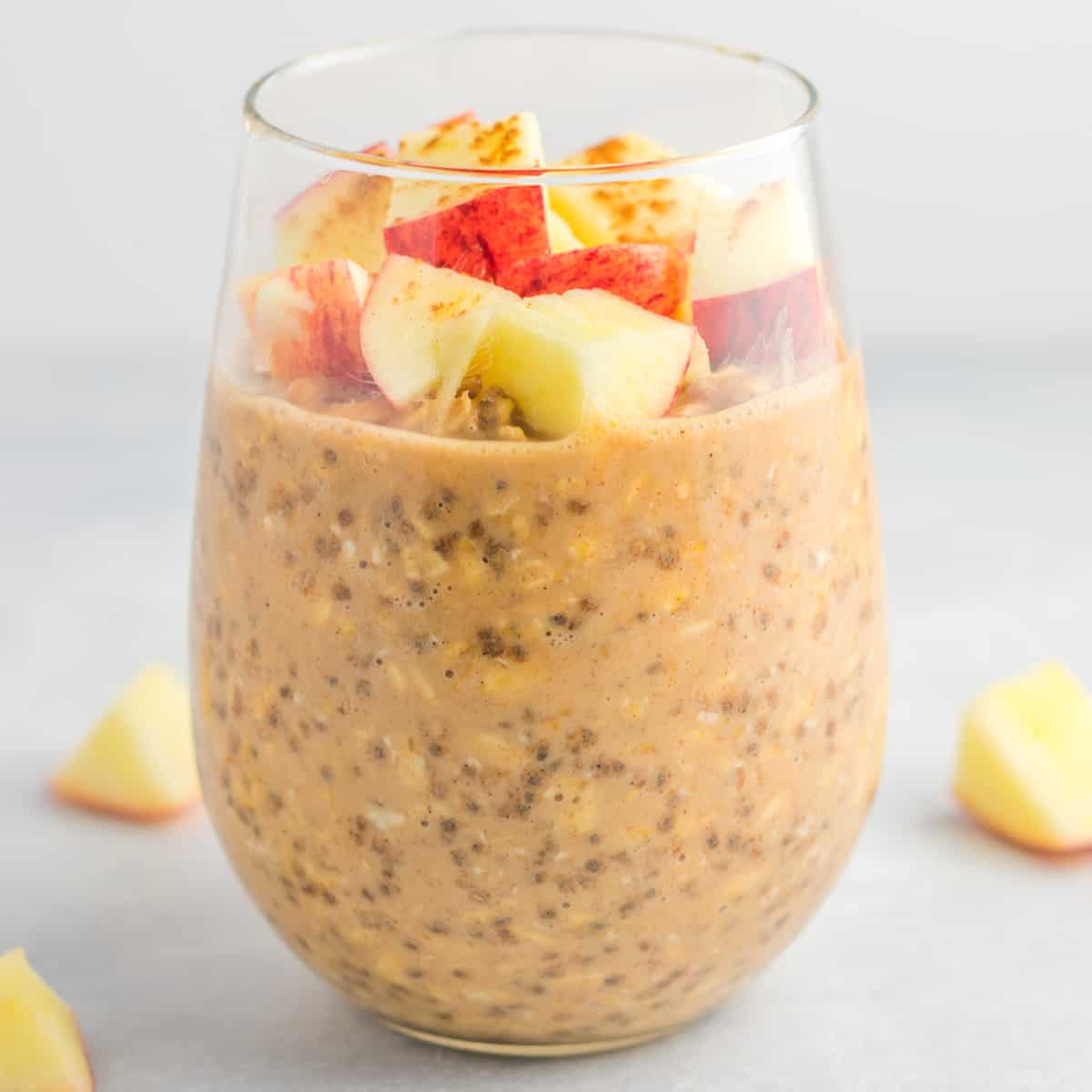 overnight oats in a glass topped with diced apples and cinnamon