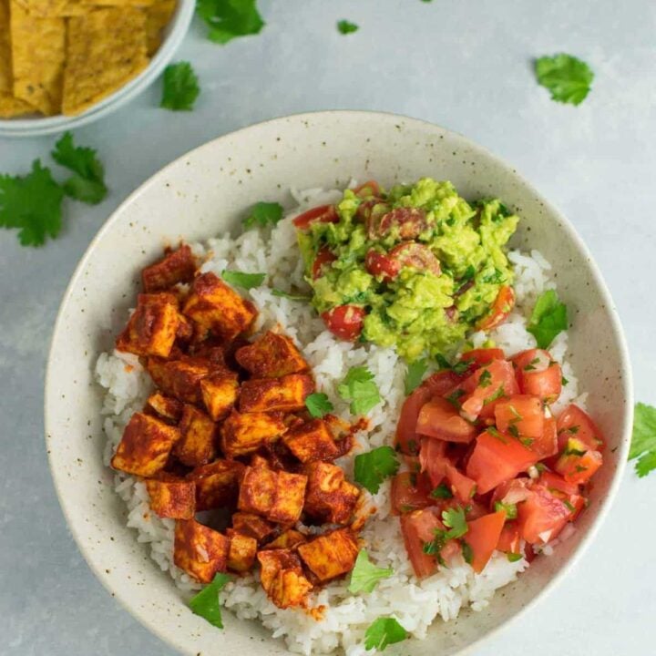 Easy enchilada tofu burrito bowls with homemade guacamole and salsa. Bring chipotle to your kitchen with this delicious recipe! #vegan #burritobowls #tofuburritobowls