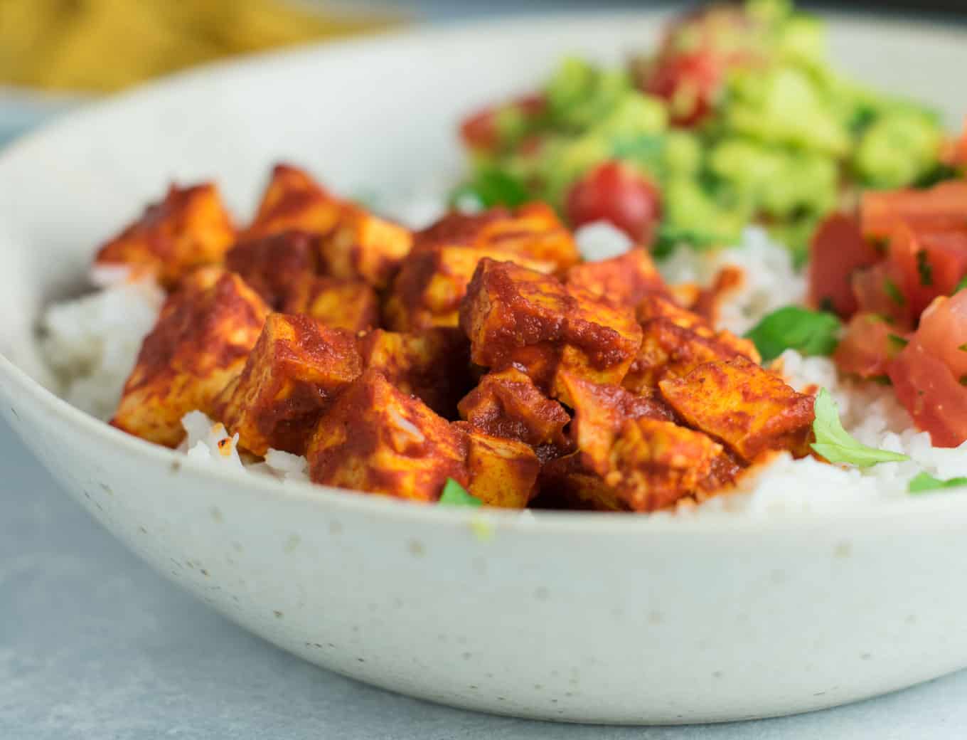 Easy enchilada tofu burrito bowls with homemade guacamole and salsa. Bring chipotle to your kitchen with this delicious recipe! #vegan #burritobowls #tofuburritobowls