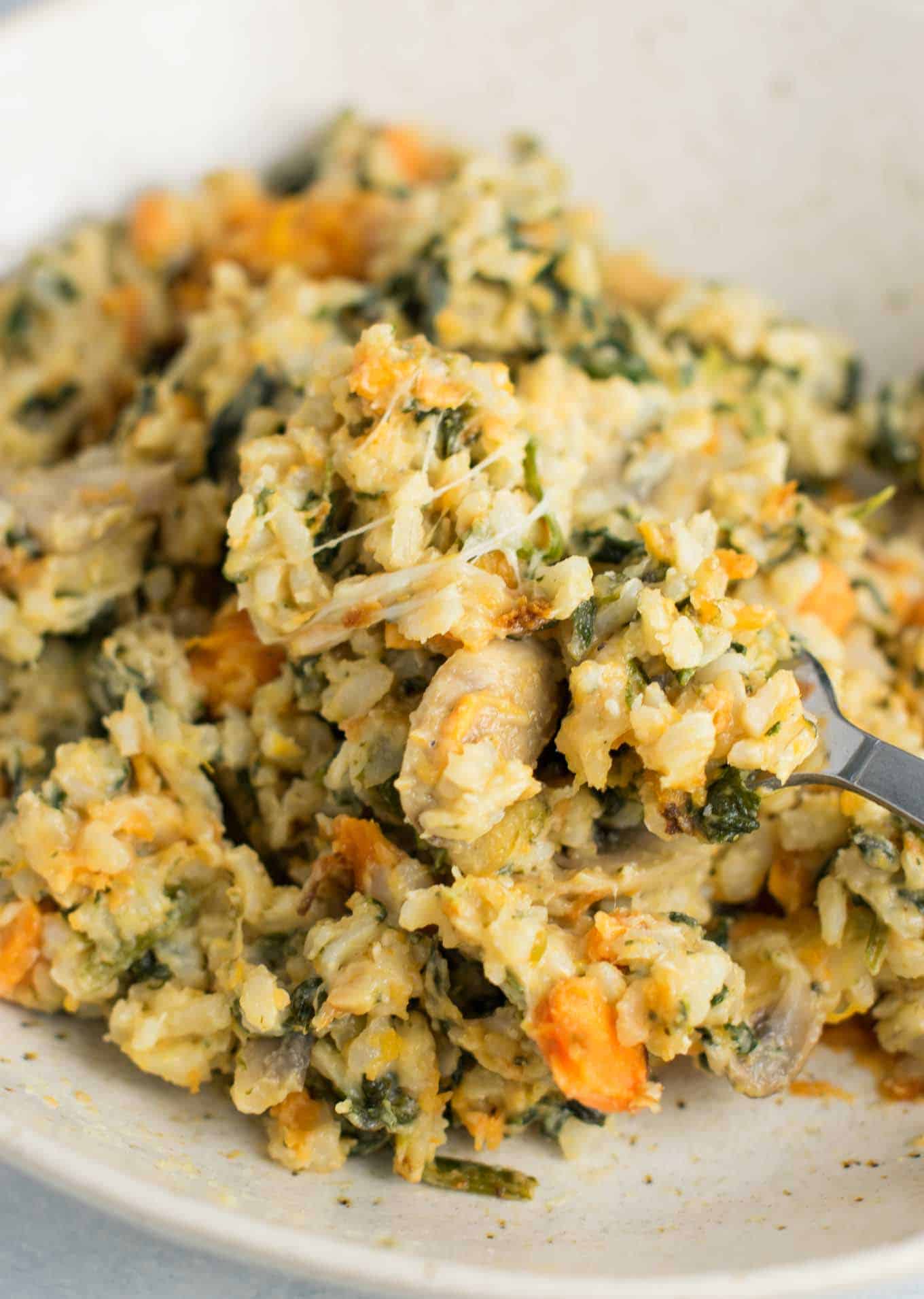 Sweet Potato Brown Rice Casserole made with greek yogurt, mushrooms, spinach, mozzarella, parmesan, and cheddar cheese - a hearty vegetarian comfort food recipe. No cream of anything soup! #casserole #vegetarian #sweetpotatobrownricecasserole #brownrice