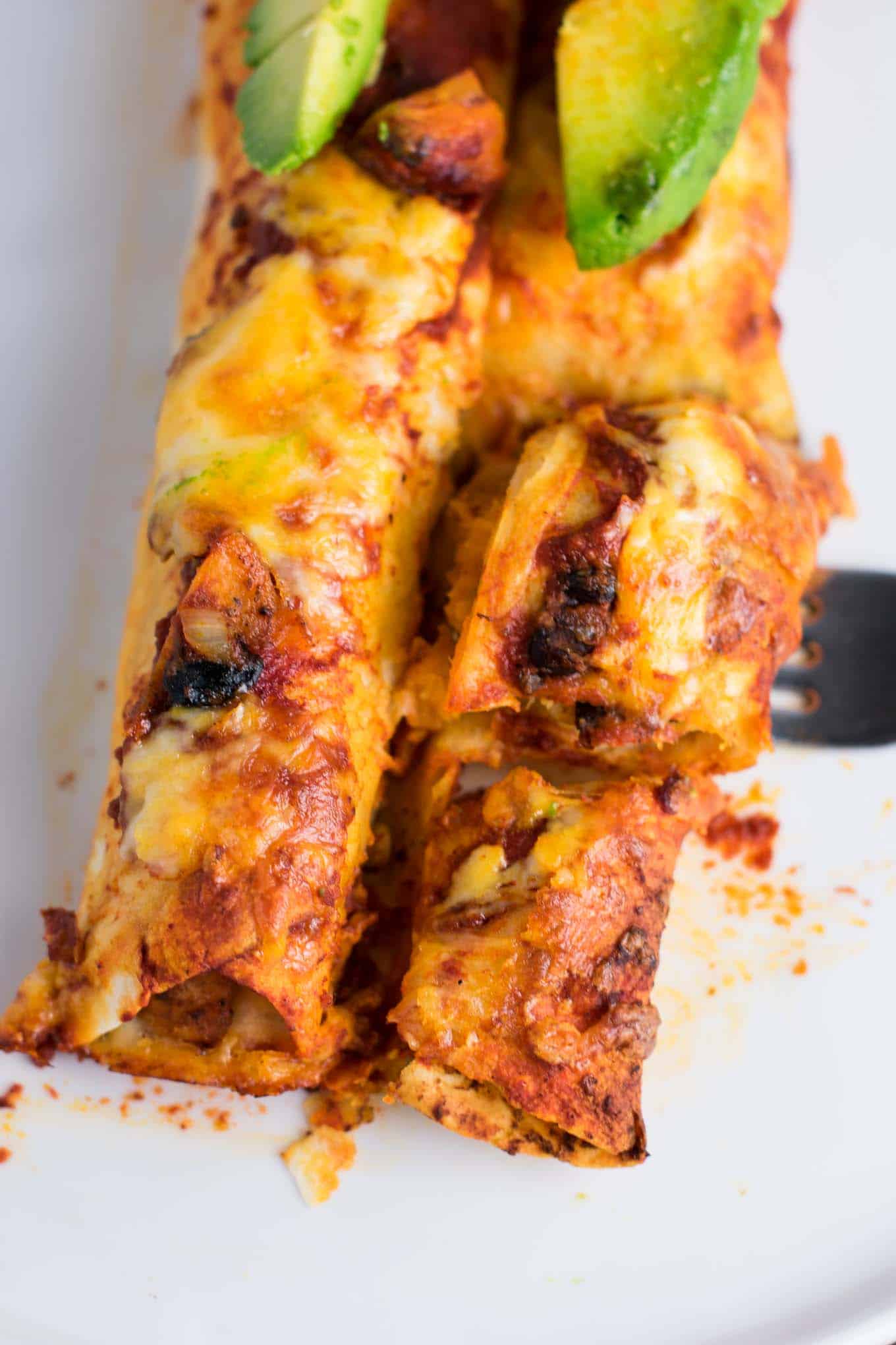 Smoky Sweet potato black bean enchiladas recipe. Even meat eaters will flip for these delicious enchiladas covered in sauce and freshly grated Colby jack. #meatless #dinner #vegetarian #enchiladas