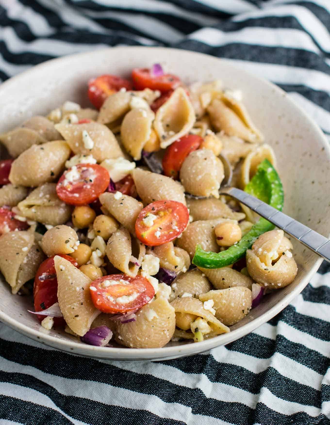 This Chickpea Pasta Salad with whole wheat pasta is an easy vegetarian pasta salad recipe. Perfect to take to parties, or as a healthy meal prep lunch. So addicting and full of good for you ingredients! #vegetarian #pastasalad #chickpea #feta #vegetarianpastasalad