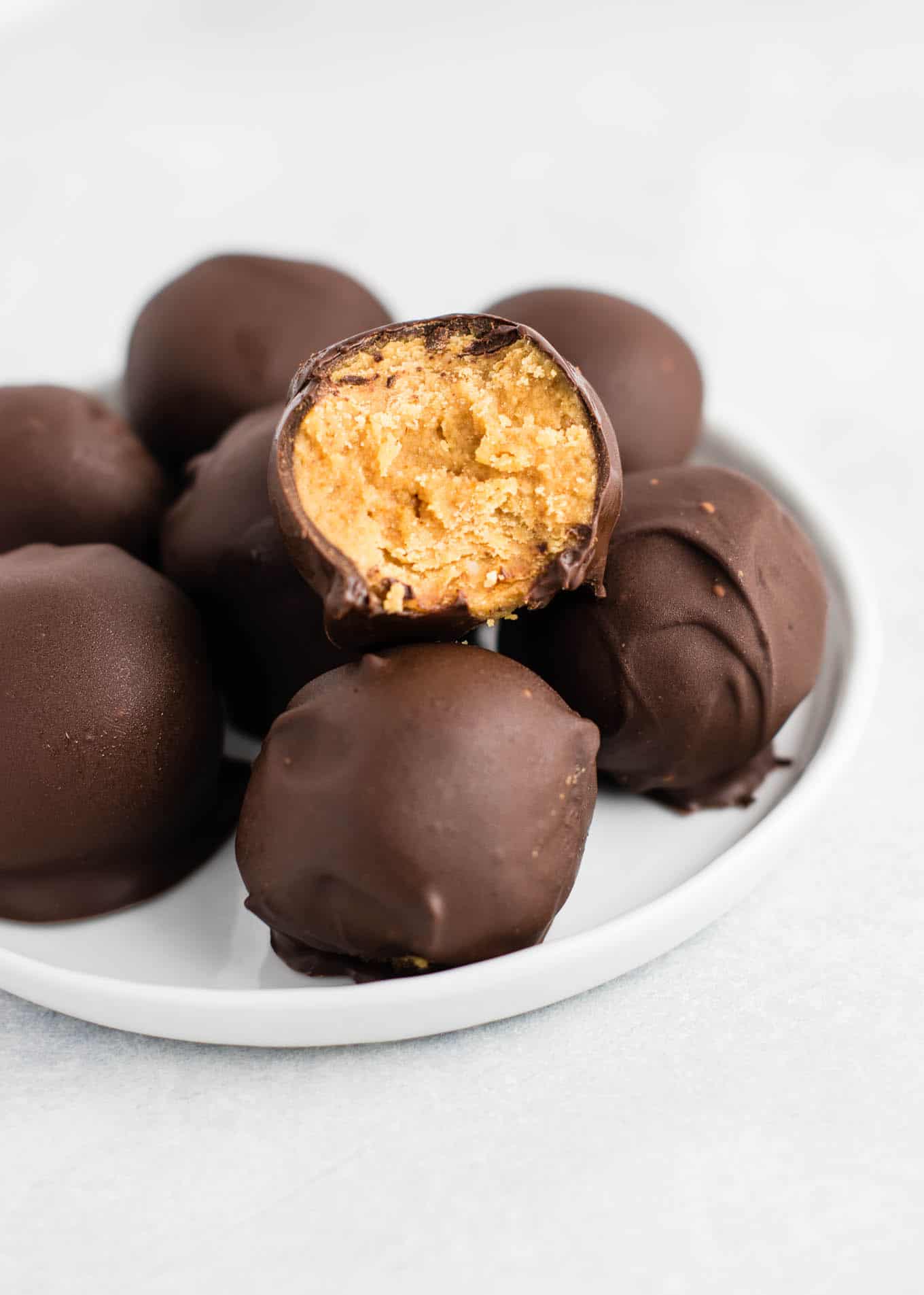 Healthy No Bake Peanut Butter Truffles recipe made with all vegan and gluten free ingredients. A healthier alternative without sacrificing flavor! NO ONE will guess this is a healthy recipe! #vegan #glutenfree #peanutbutter #nobake #dessert