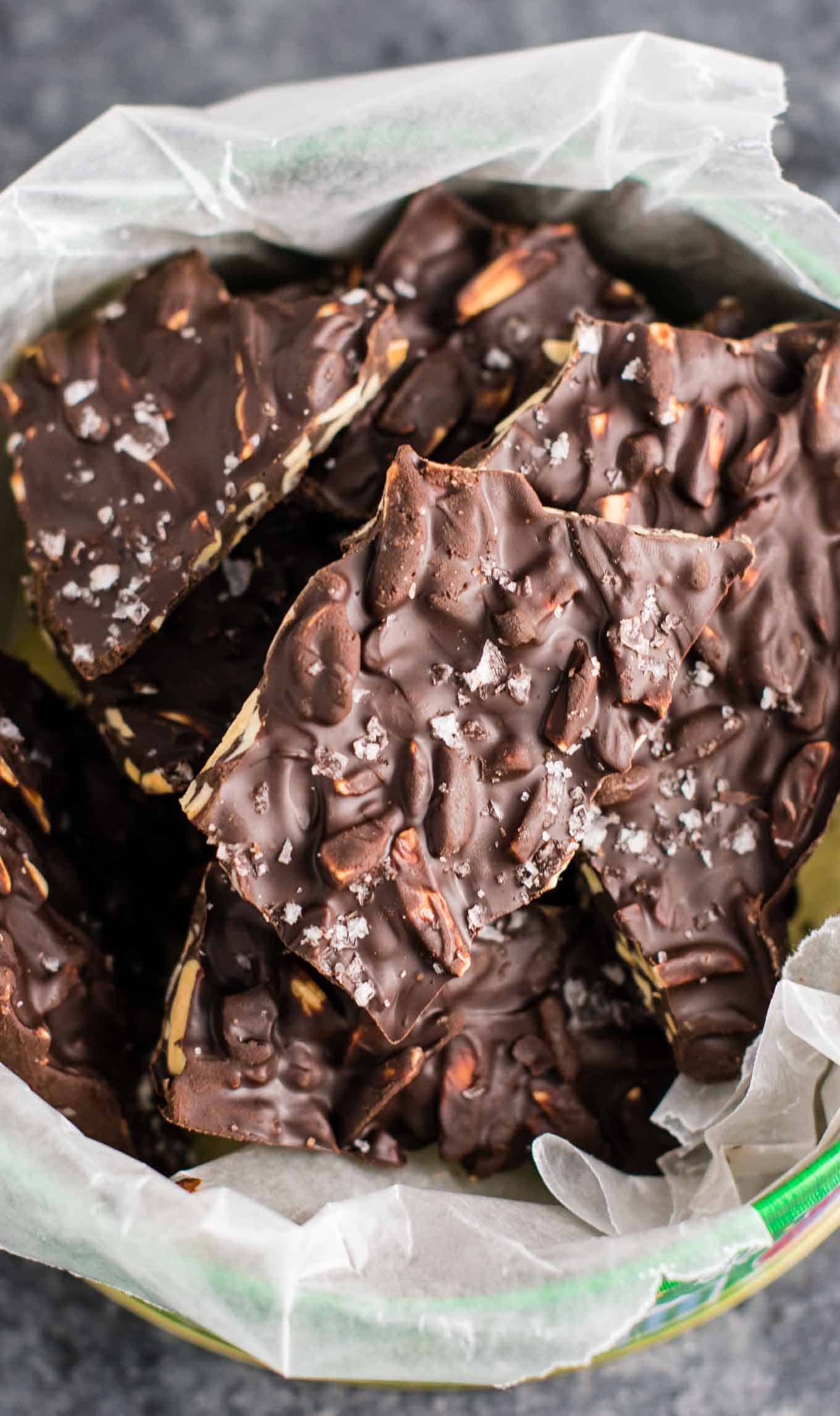 chocolate almond bark in a christmas tin lined with wax paper