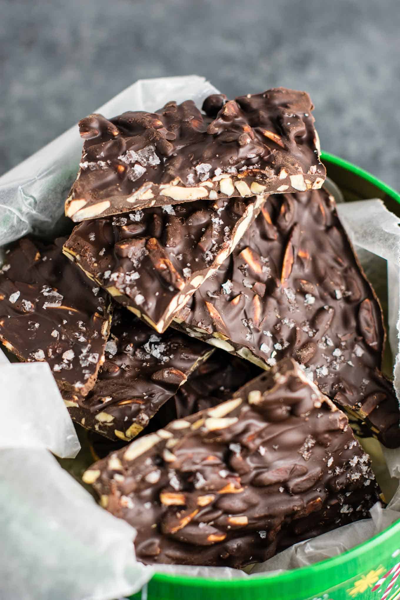 chocolate almond bark in a christmas tin lined with wax paper
