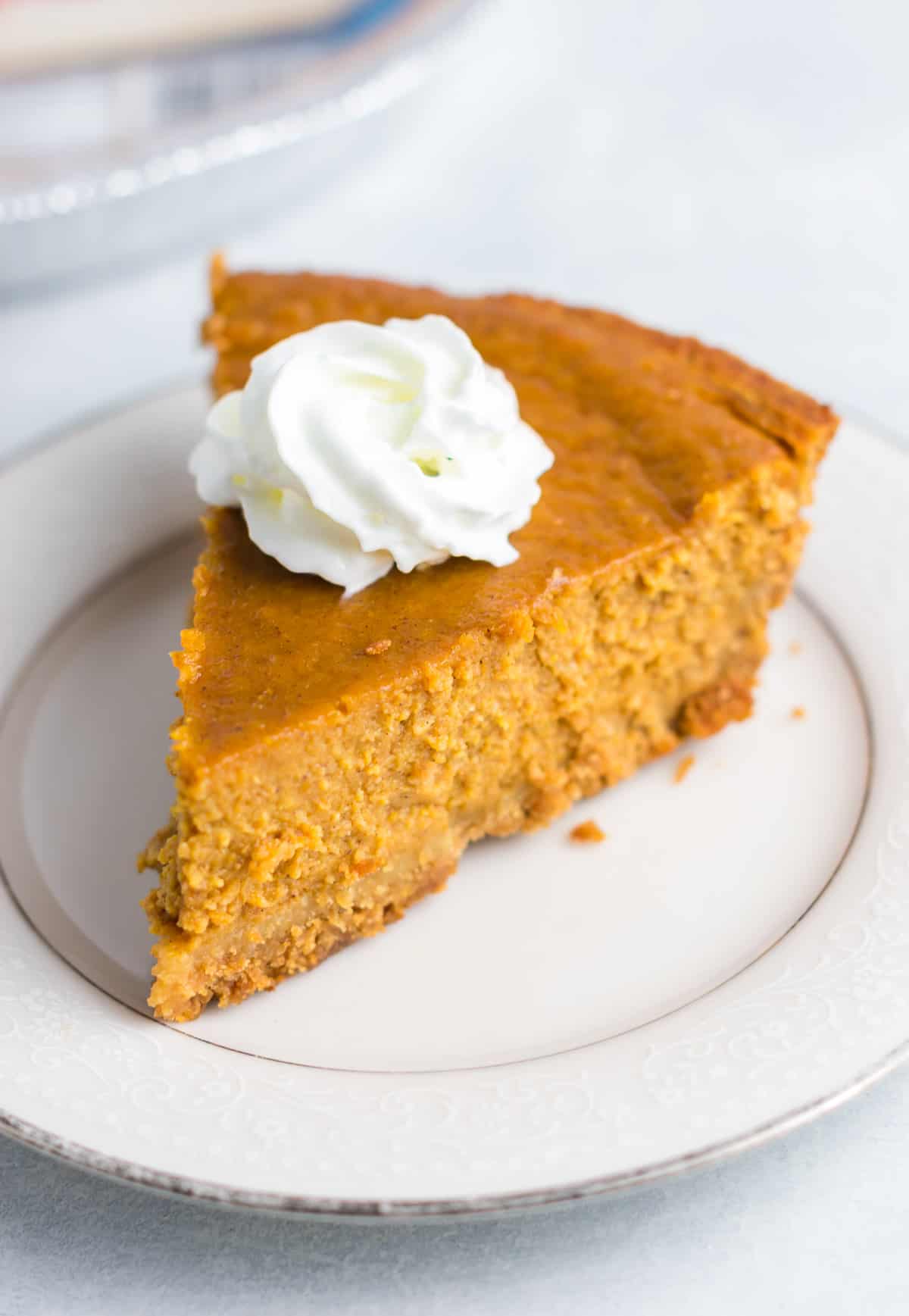 a slice of pumpkin pie on a plate topped with whipped cream