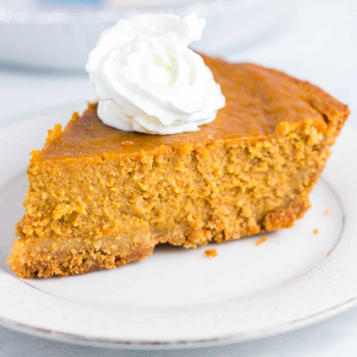 a slice of pumpkin pie on a plate topped with whipped cream