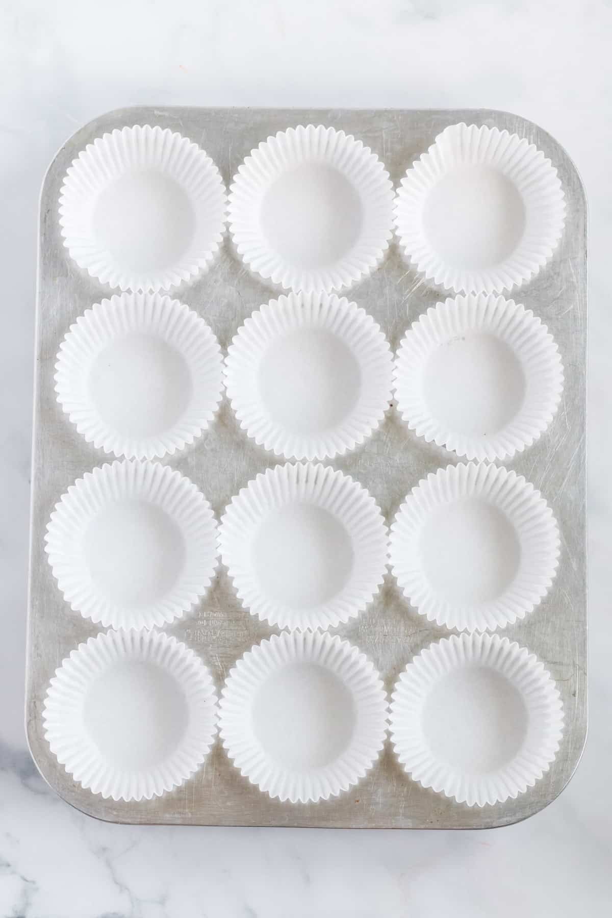 muffin tin lined with white muffin liners