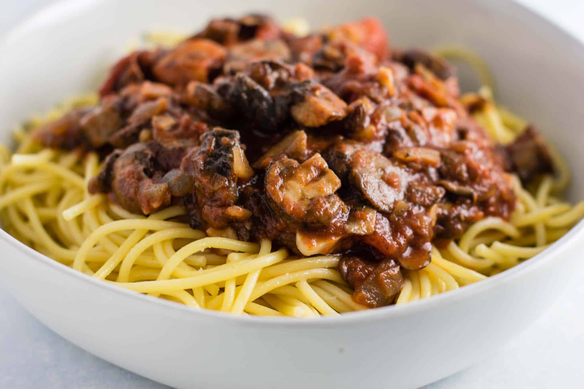 meatless spaghetti sauce over pasta in a white bowl