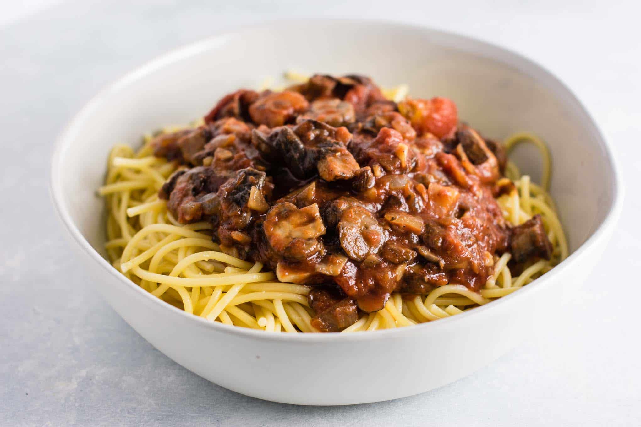 meatless spaghetti sauce over pasta in a white bowl