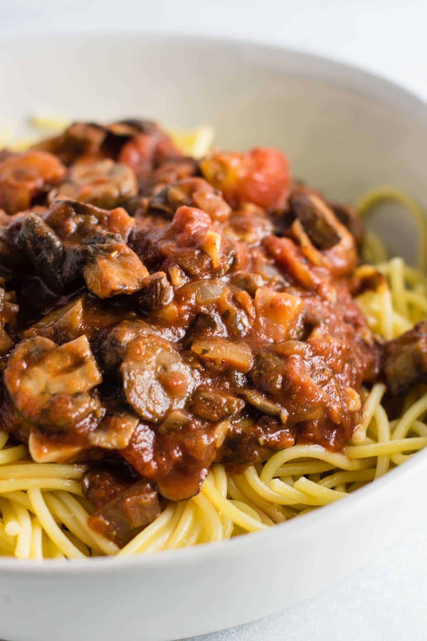 vegan spaghetti sauce over white spaghetti noodles in a bowl