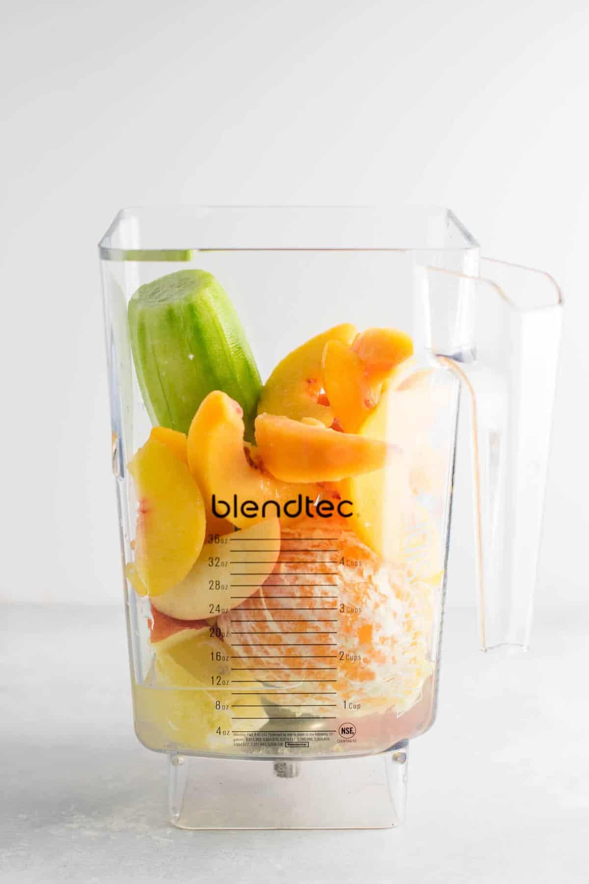 cucumber, lemon, apples, orange, peaches, and water in a blender