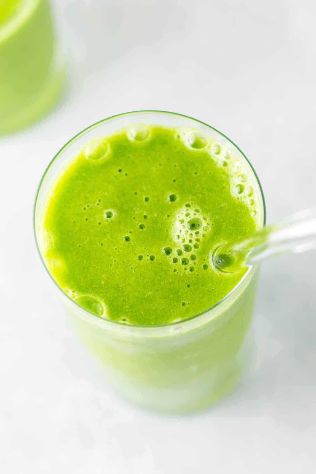 green smoothie in a glass with a straw