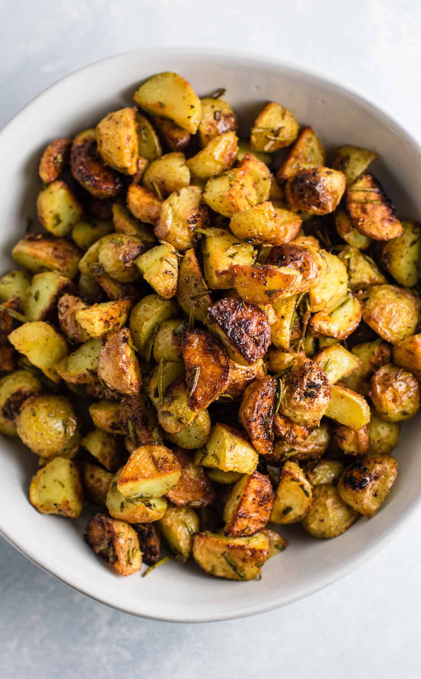 Rosemary roasted potatoes recipe made with fresh rosemary and olive oil. Everyone will love this easy side dish! #rosemaryroastedpotatoes #vegan #sidedish #roastedpotatoes