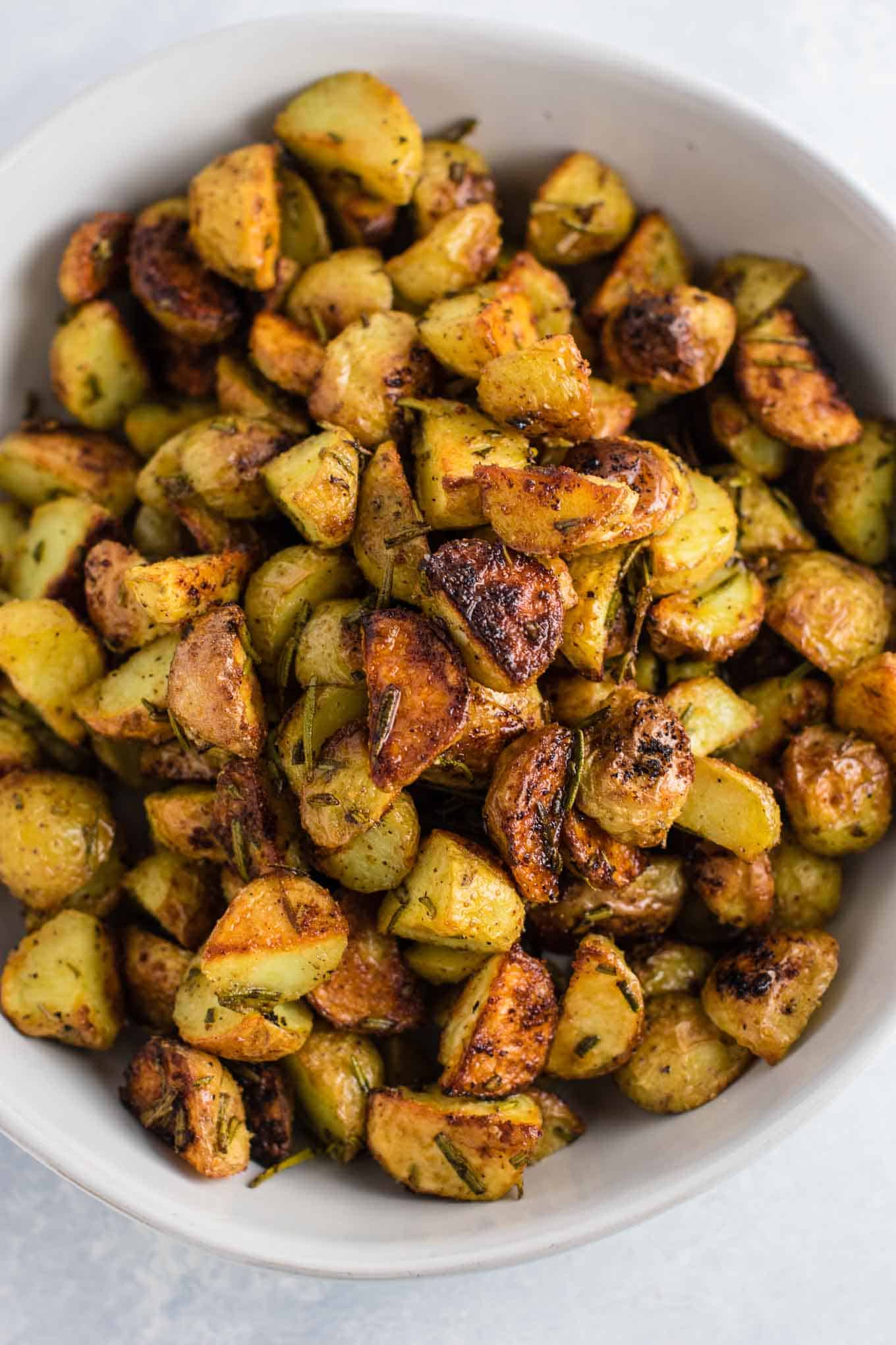 Rosemary roasted potatoes recipe made with fresh rosemary and olive oil. Everyone will love this easy side dish! #rosemaryroastedpotatoes #vegan #sidedish #roastedpotatoes