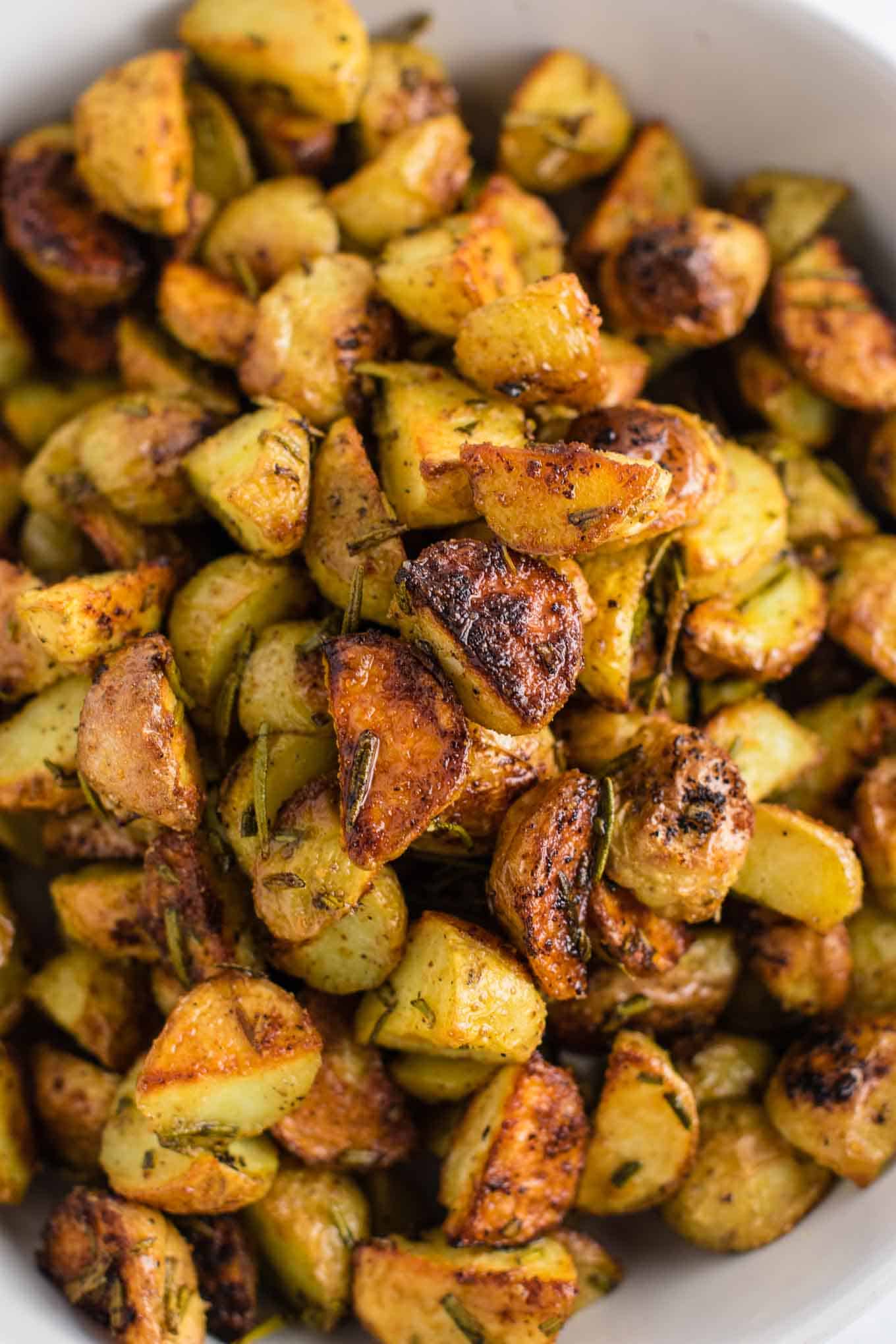 Rosemary roasted potatoes recipe made with fresh rosemary and olive oil. Everyone will love this easy side dish! #rosemaryroastedpotatoes #vegan #sidedish #roastedpotatoes