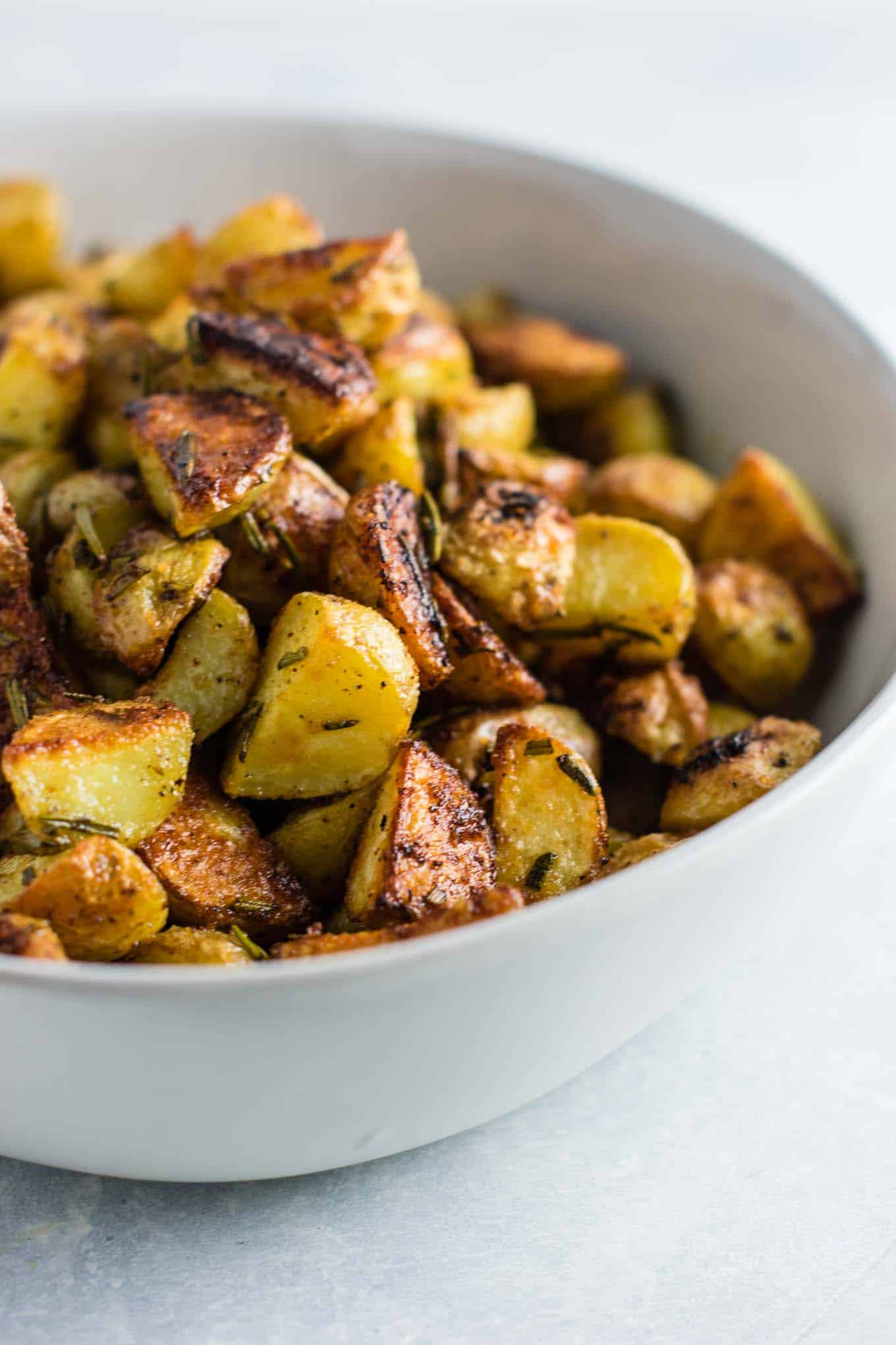 Rosemary roasted potatoes recipe made with fresh rosemary and olive oil. Everyone will love this easy side dish! #rosemaryroastedpotatoes #vegan #sidedish #roastedpotatoes
