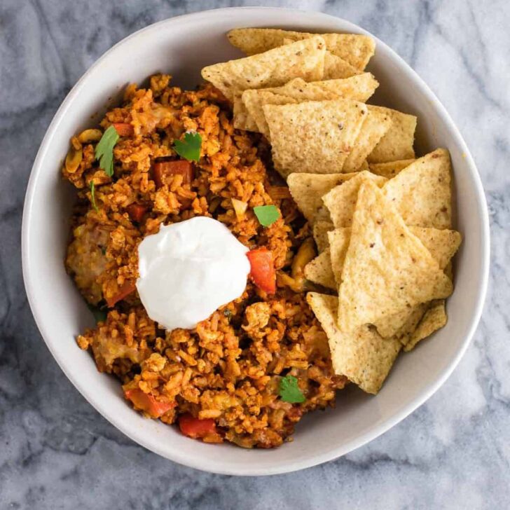 Tofu Mexican Rice Casserole Recipe with bell peppers and mushrooms. Scrambled tofu adds extra protein to this delicious vegetarian take on a healthier Mexican rice casserole. Serve with chips and sour cream! #tofumexicanrice #mexicanricecasserole #healthymexicanrice #tofu #vegetarian #dinner