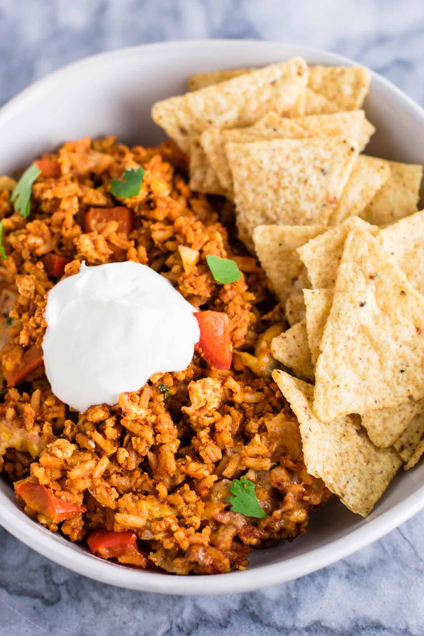 Tofu Mexican Rice Casserole Recipe with bell peppers and mushrooms. Scrambled tofu adds extra protein to this delicious vegetarian take on a healthier Mexican rice casserole. Serve with chips and sour cream! #tofumexicanrice #mexicanricecasserole #healthymexicanrice #tofu #vegetarian #dinner