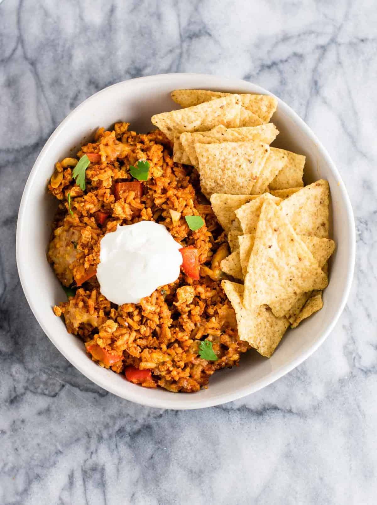 Tofu Mexican Rice Casserole Recipe with bell peppers and mushrooms. Scrambled tofu adds extra protein to this delicious vegetarian take on a healthier Mexican rice casserole. Serve with chips and sour cream! #tofumexicanrice #mexicanricecasserole #healthymexicanrice #tofu #vegetarian #dinner