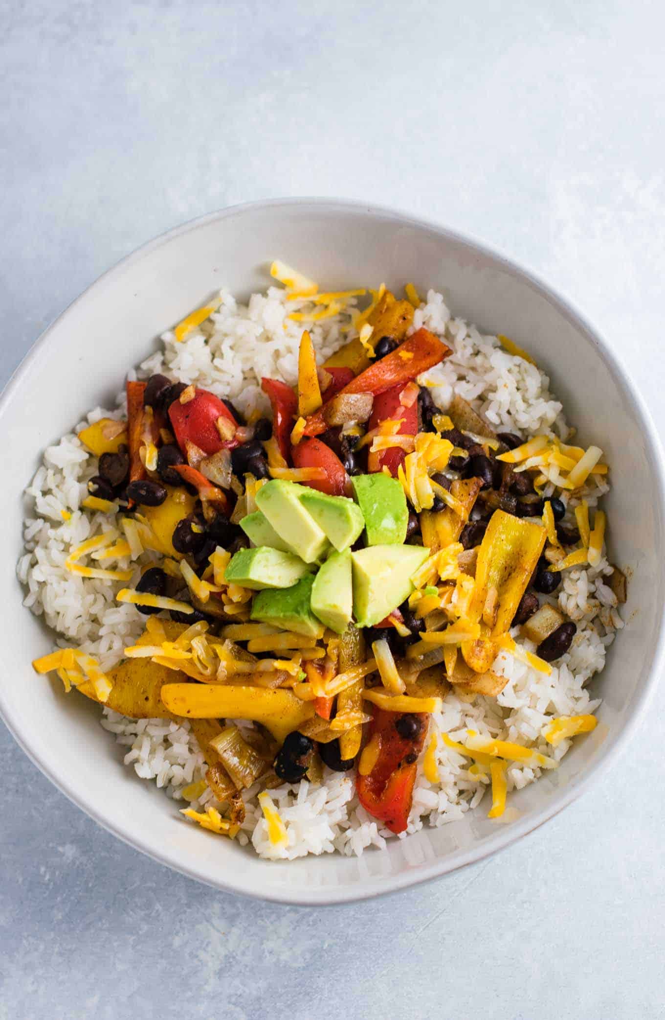 Vegetarian burrito bowl recipe with black beans, mini bell peppers, garlic, and onion. Better than chipotle! An easy vegetarian meal prep recipe or dinner the whole family will love! #vegetarianmealprep #vegetarianburritobowl #dinner #healthy #vegetarian