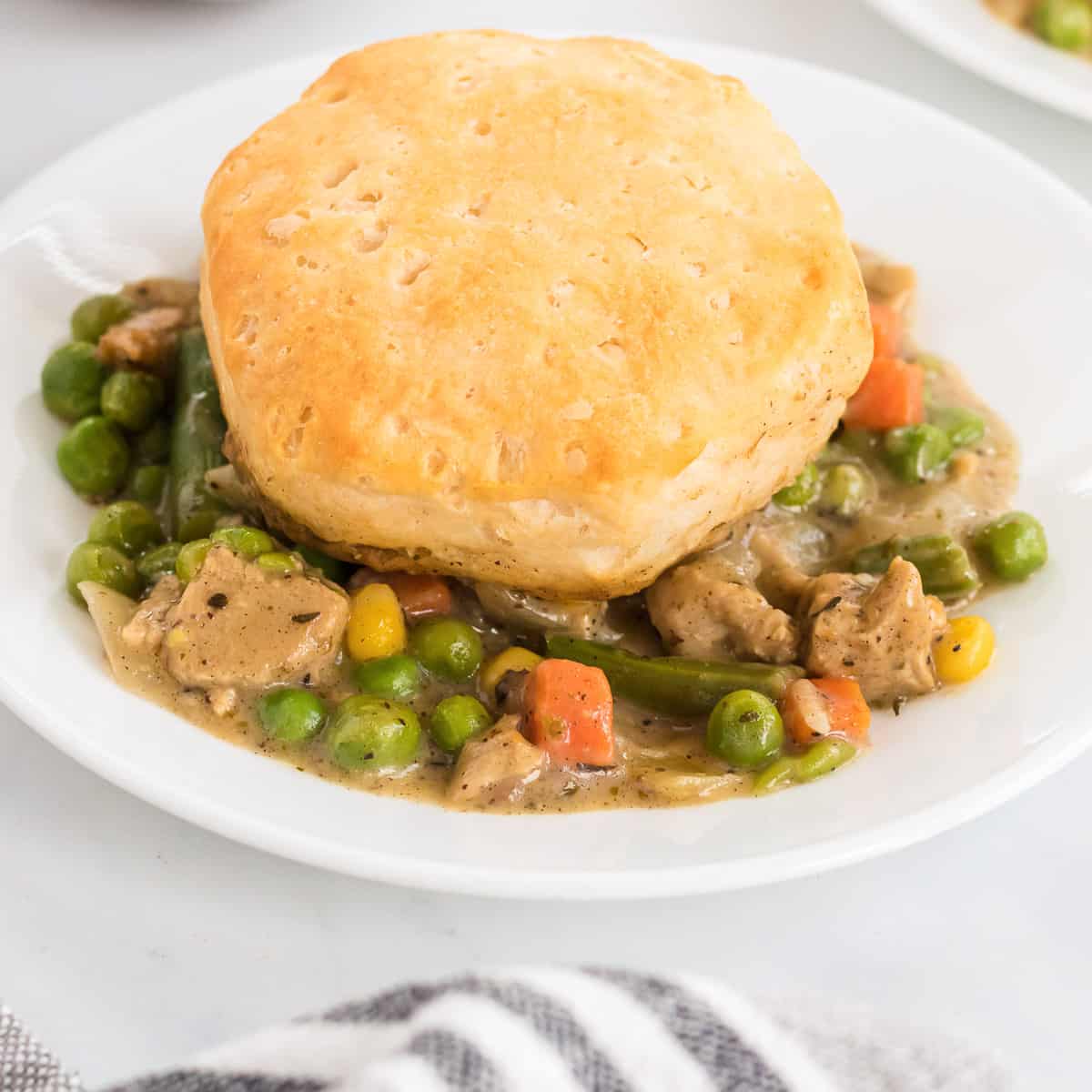 veggie pot pie topped with a biscuit on a plate