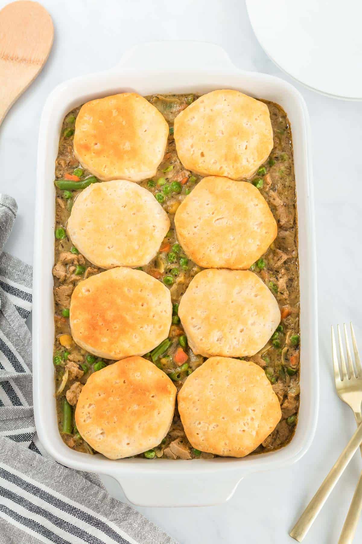 veggie pot pie in a casserole dish topped with biscuits