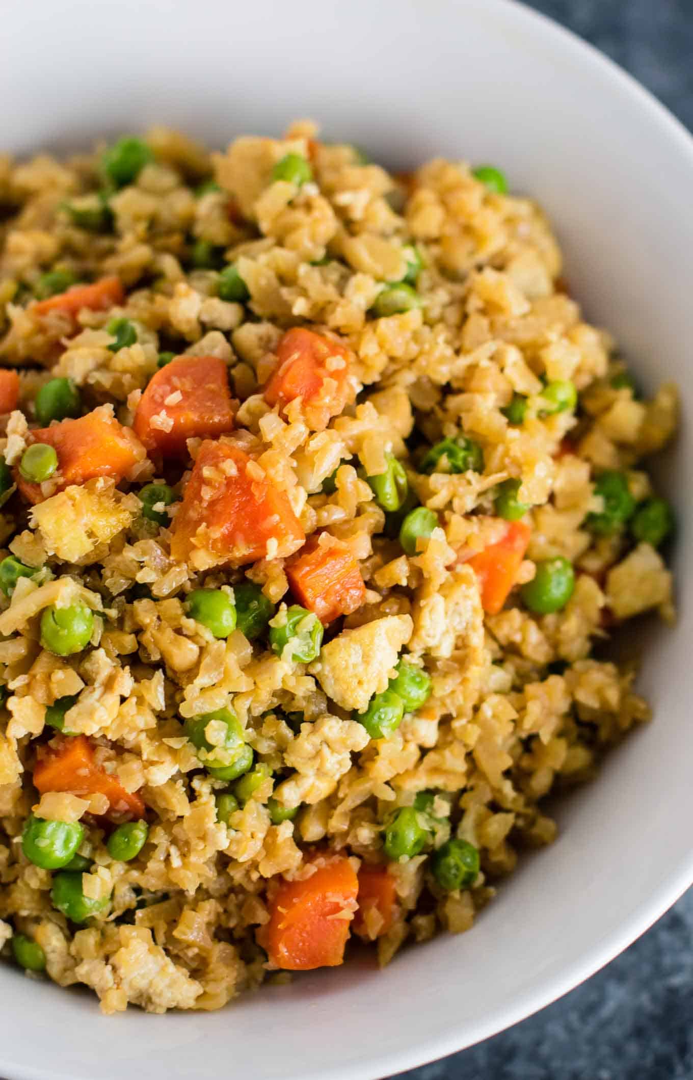 This cauliflower tofu fried rice is vegan, gluten free, grain free, and low carb. You won't believe this doesn't have rice or eggs in it! My new favorite dinner recipe! #grainfree #glutenfree #cauliflowerfriedrice #tofufriedrice #vegan #dinner #eggfree