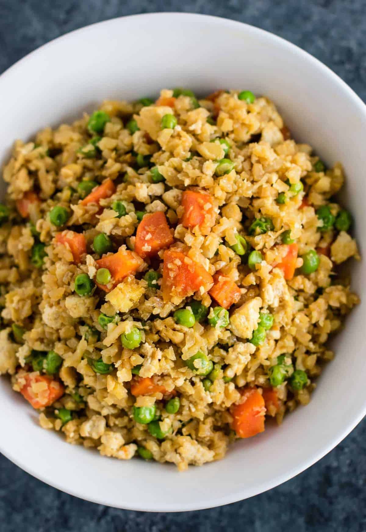 This cauliflower tofu fried rice is vegan, gluten free, grain free, and low carb. You won't believe this doesn't have rice or eggs in it! My new favorite dinner recipe! #grainfree #glutenfree #cauliflowerfriedrice #tofufriedrice #vegan #dinner #eggfree