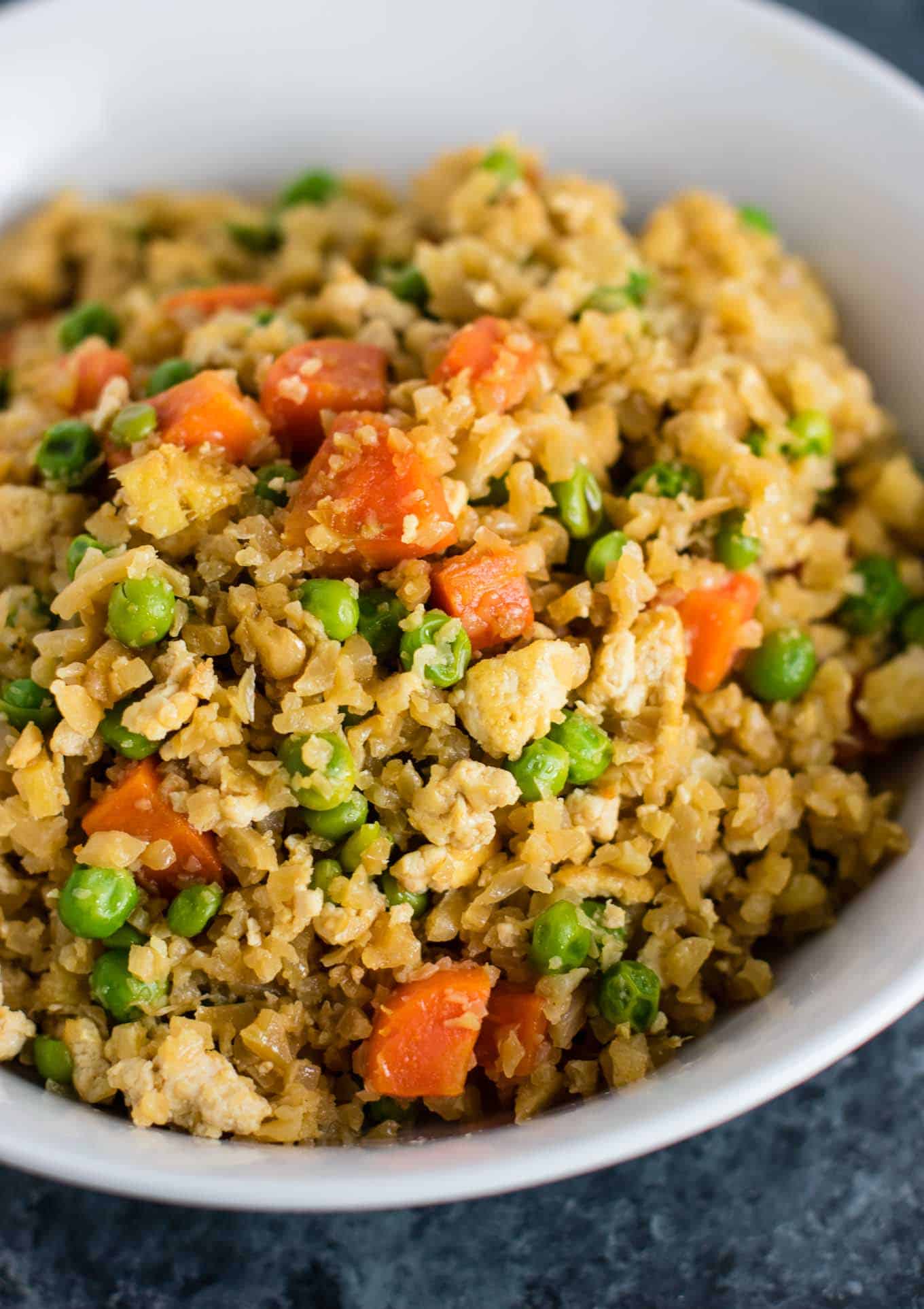 This cauliflower tofu fried rice is vegan, gluten free, grain free, and low carb. You won't believe this doesn't have rice or eggs in it! My new favorite dinner recipe! #grainfree #glutenfree #cauliflowerfriedrice #tofufriedrice #vegan #dinner #eggfree