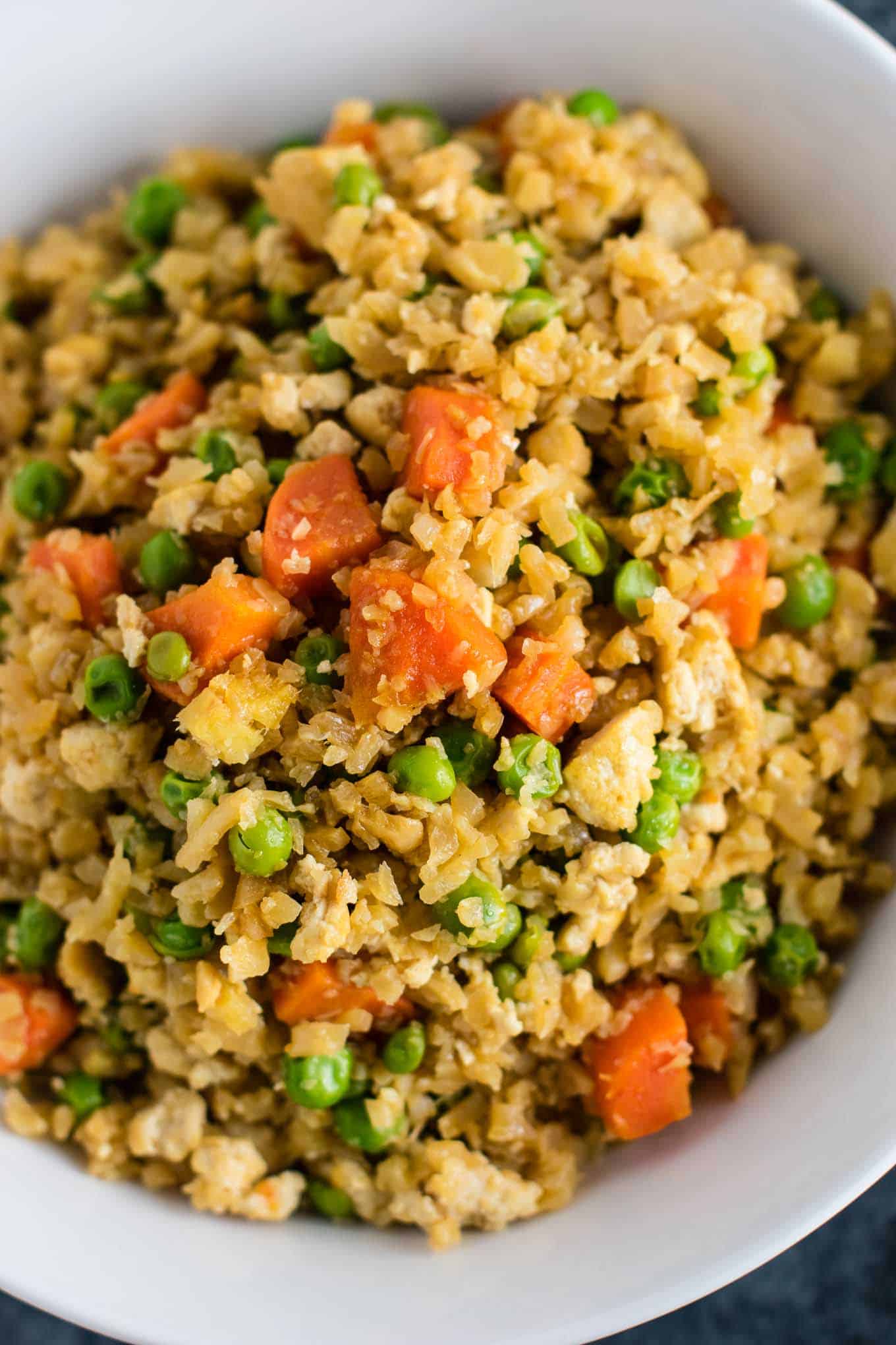 This cauliflower tofu fried rice is vegan, gluten free, grain free, and low carb. You won't believe this doesn't have rice or eggs in it! My new favorite dinner recipe! #grainfree #glutenfree #cauliflowerfriedrice #tofufriedrice #vegan #dinner #eggfree