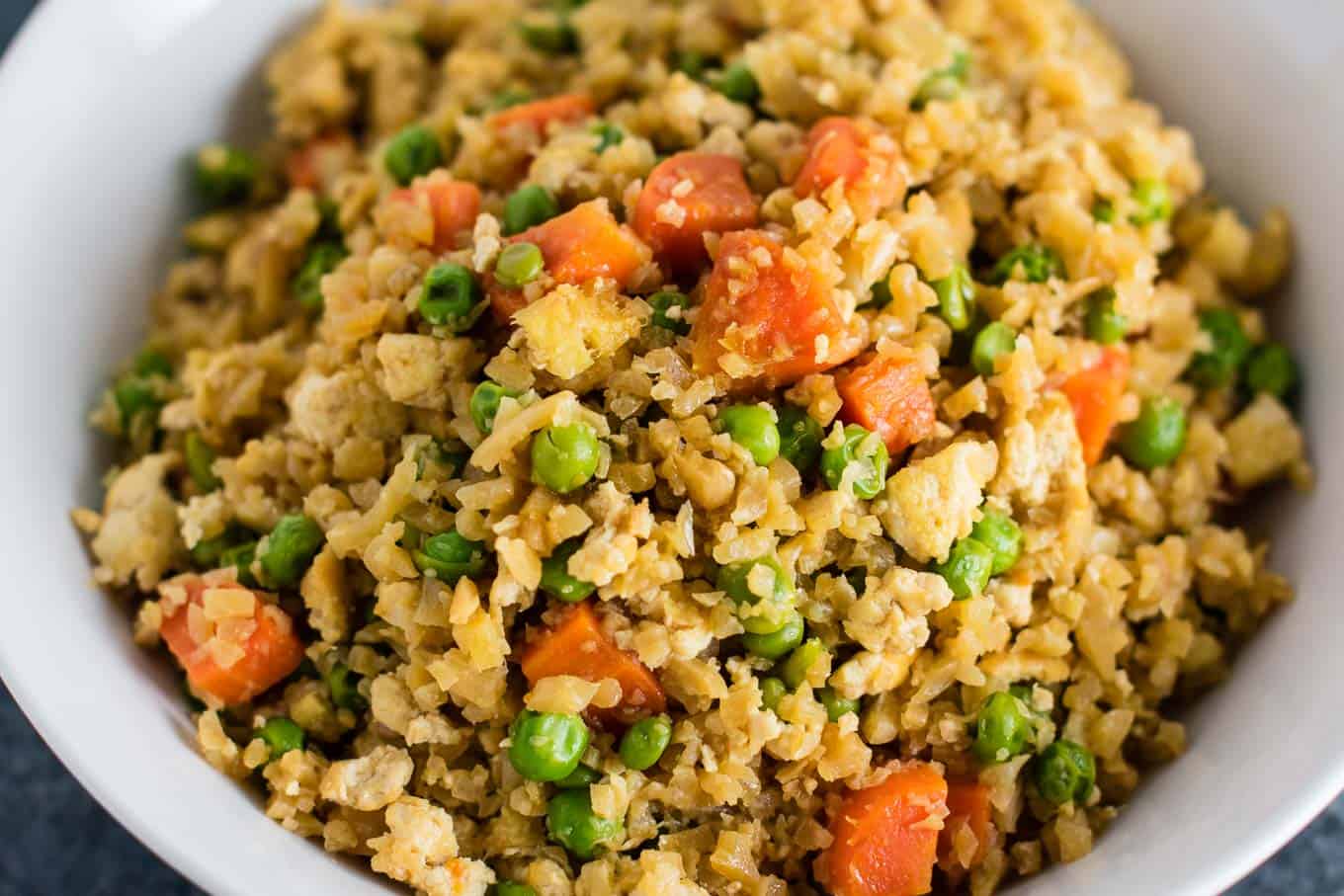 This cauliflower tofu fried rice is vegan, gluten free, grain free, and low carb. You won't believe this doesn't have rice or eggs in it! My new favorite dinner recipe! #grainfree #glutenfree #cauliflowerfriedrice #tofufriedrice #vegan #dinner #eggfree