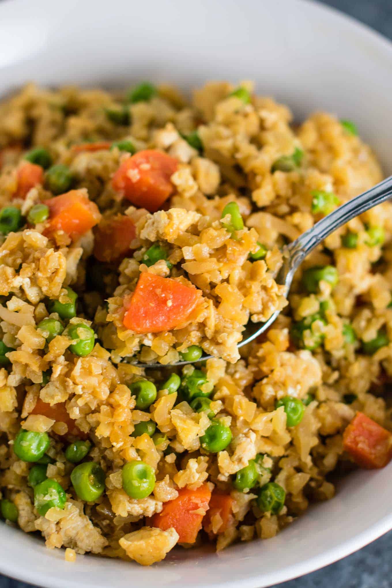 This cauliflower tofu fried rice is vegan, gluten free, grain free, and low carb. You won't believe this doesn't have rice or eggs in it! My new favorite dinner recipe! #grainfree #glutenfree #cauliflowerfriedrice #tofufriedrice #vegan #dinner #eggfree