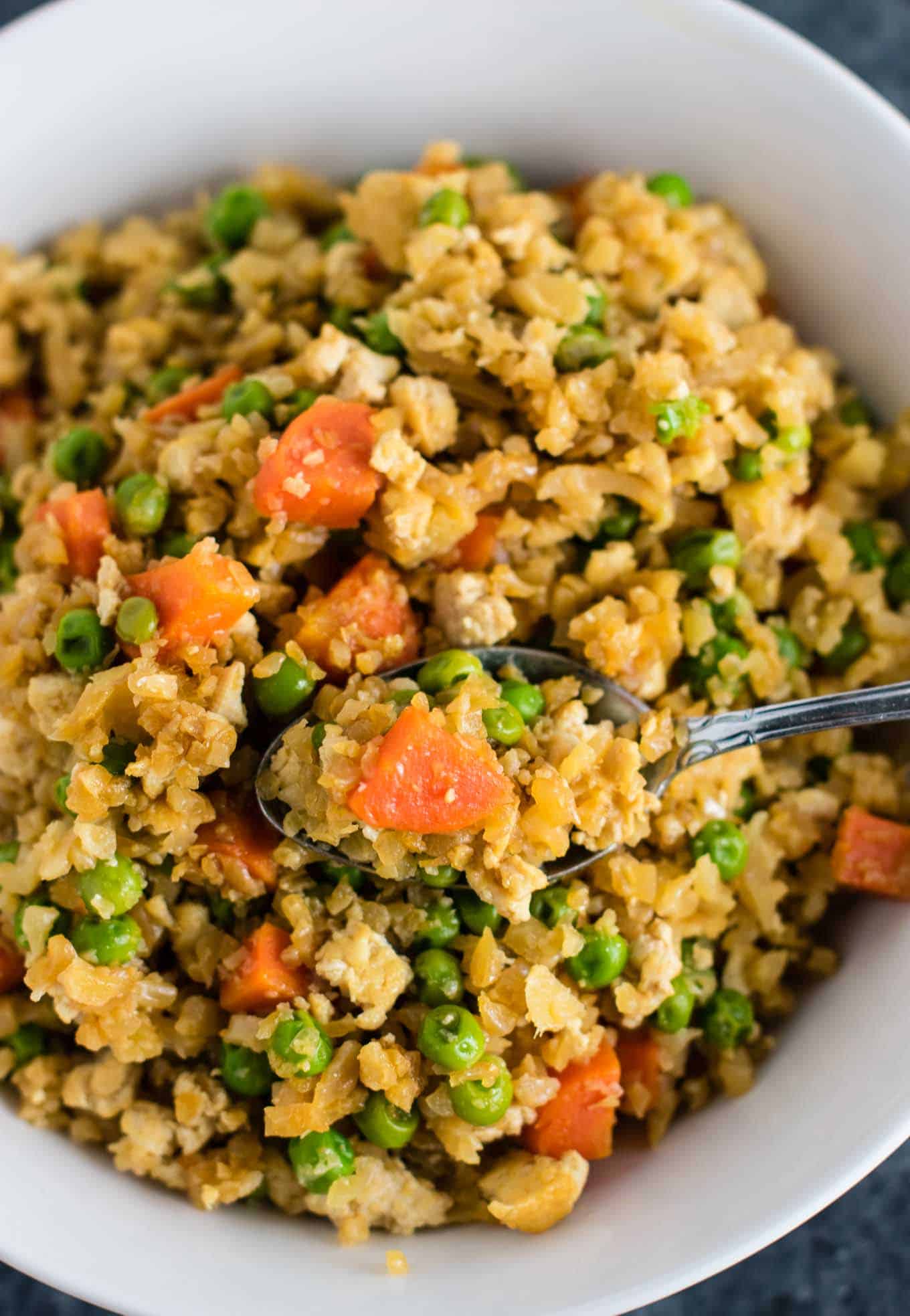 This cauliflower tofu fried rice is vegan, gluten free, grain free, and low carb. You won't believe this doesn't have rice or eggs in it! My new favorite dinner recipe! #grainfree #glutenfree #cauliflowerfriedrice #tofufriedrice #vegan #dinner #eggfree