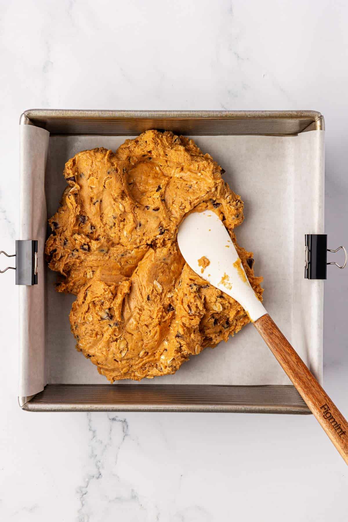 pressing the protein bar batter into an 8 by 8 baking dish