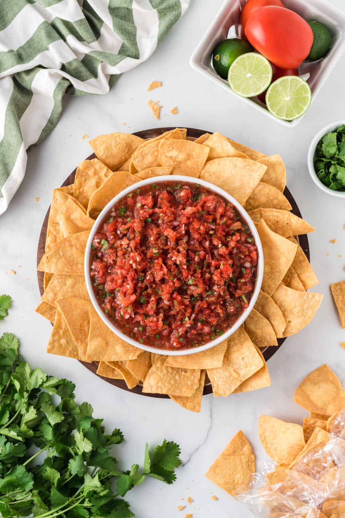 salsa in a bowl surrounded by a platter of tortilla chips