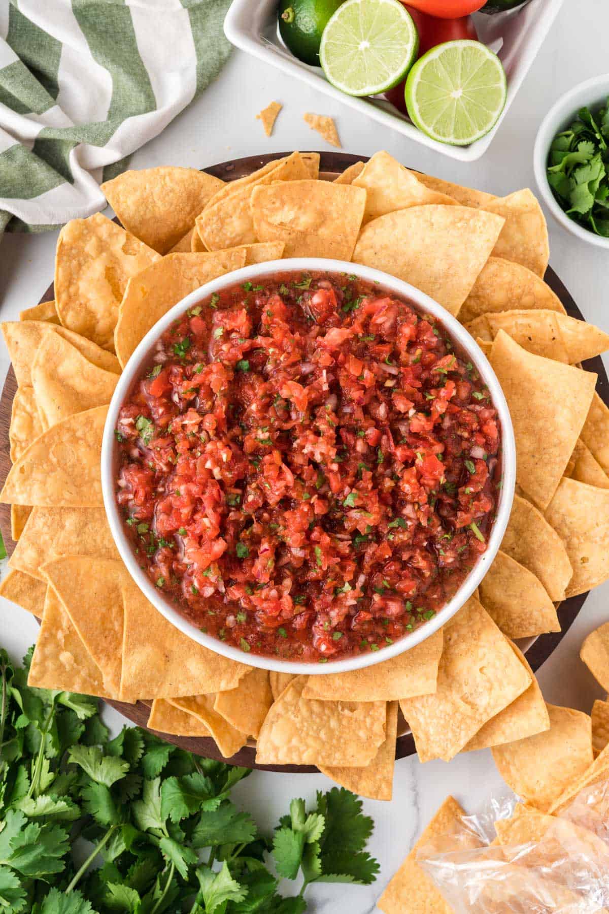 salsa in a bowl surrounded by a platter of tortilla chips