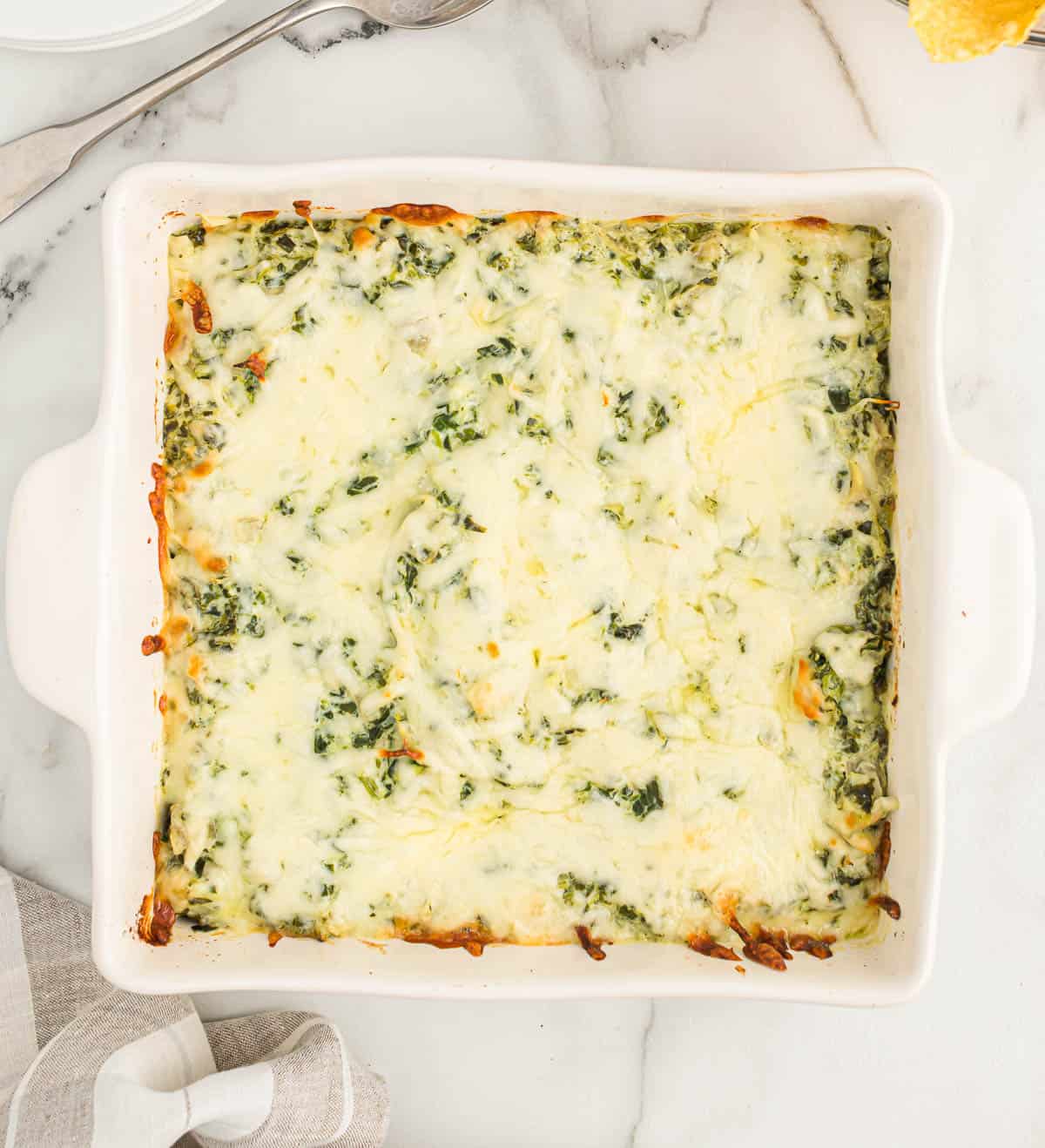 baked spinach artichoke dip in a white dish